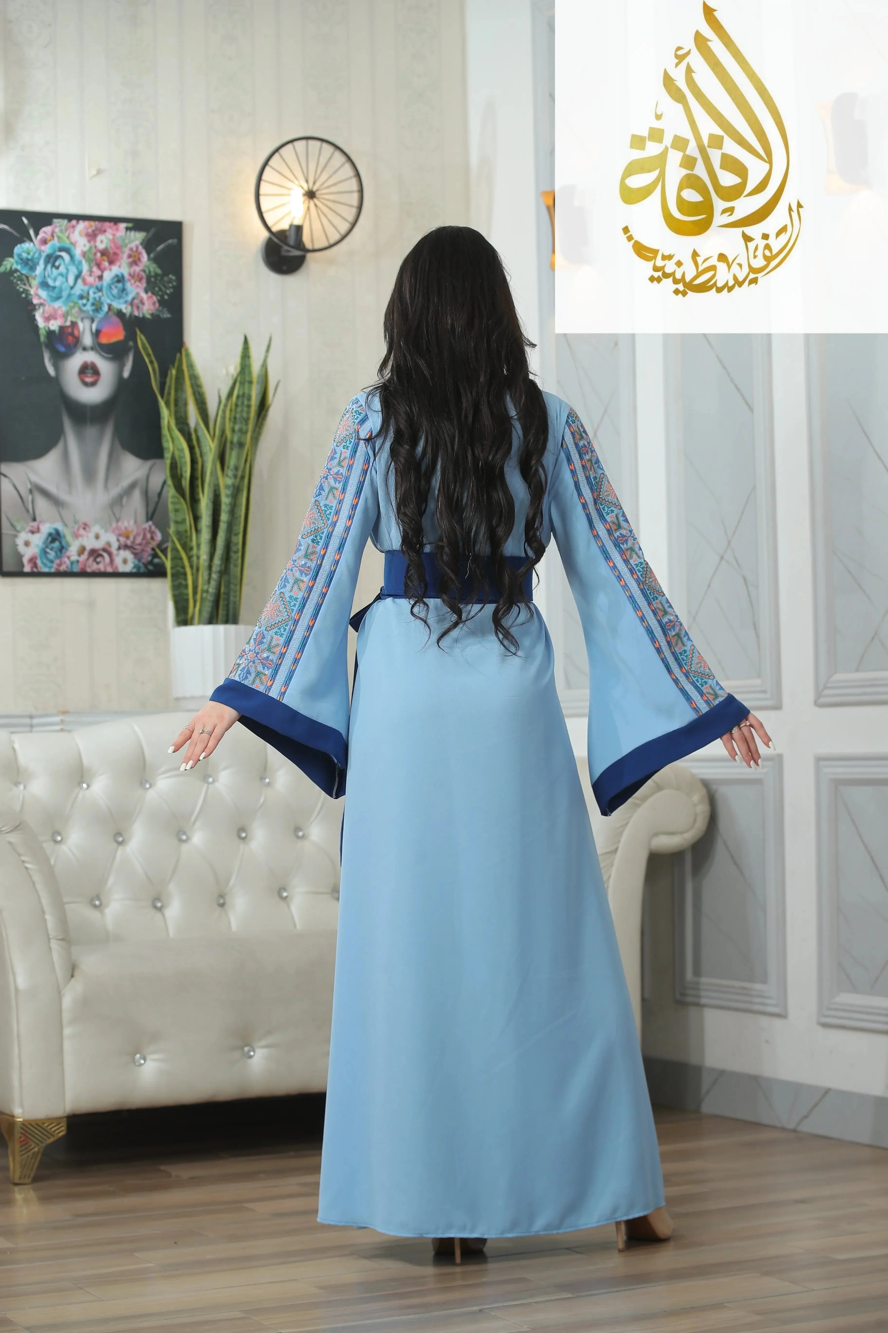 Back view of woman wearing Nadera Embroidered Thoub in light blue with detailed sleeve embroidery