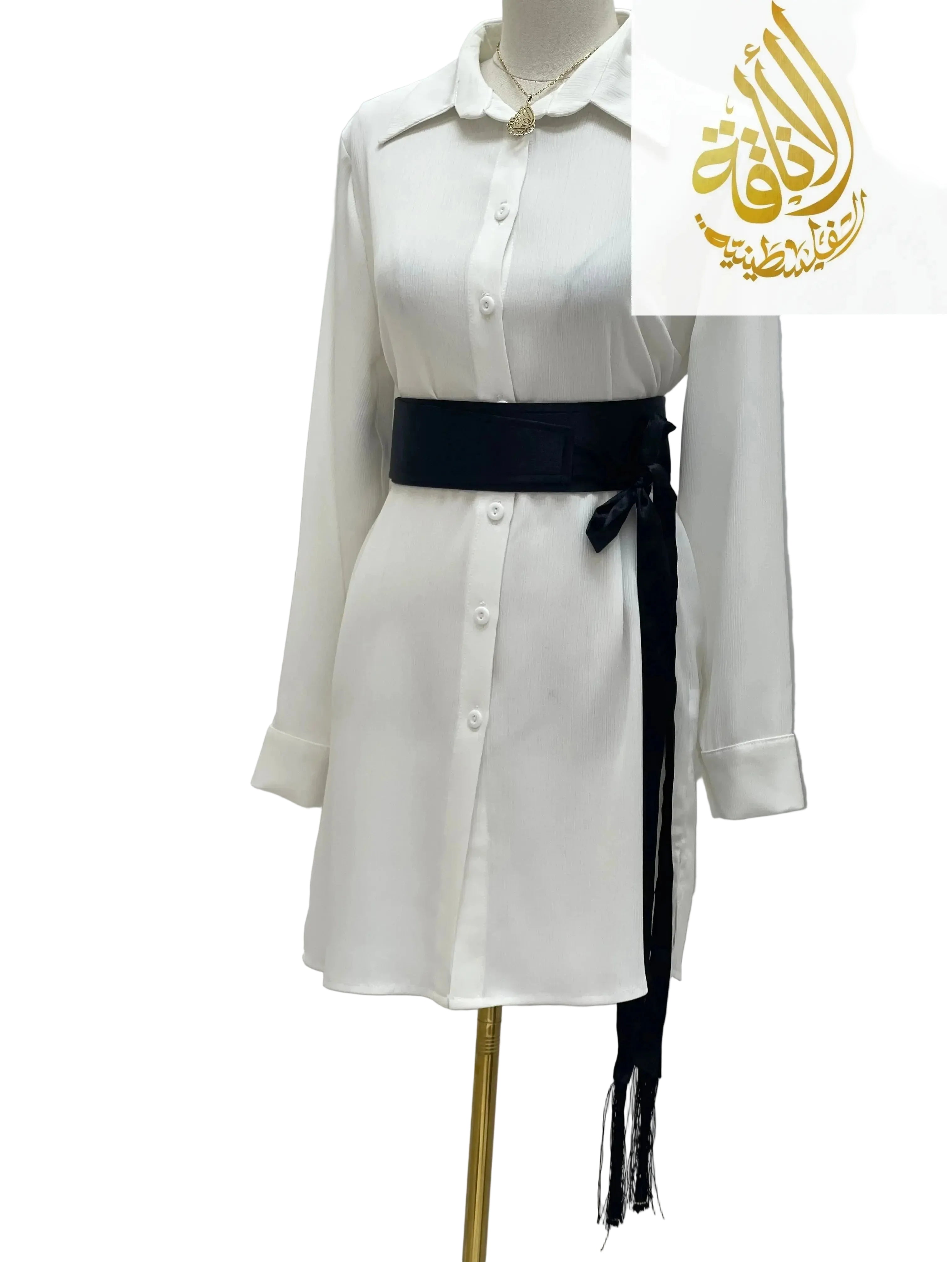 Black satin belt for dresses tied around a white long-sleeve button-down dress on a mannequin