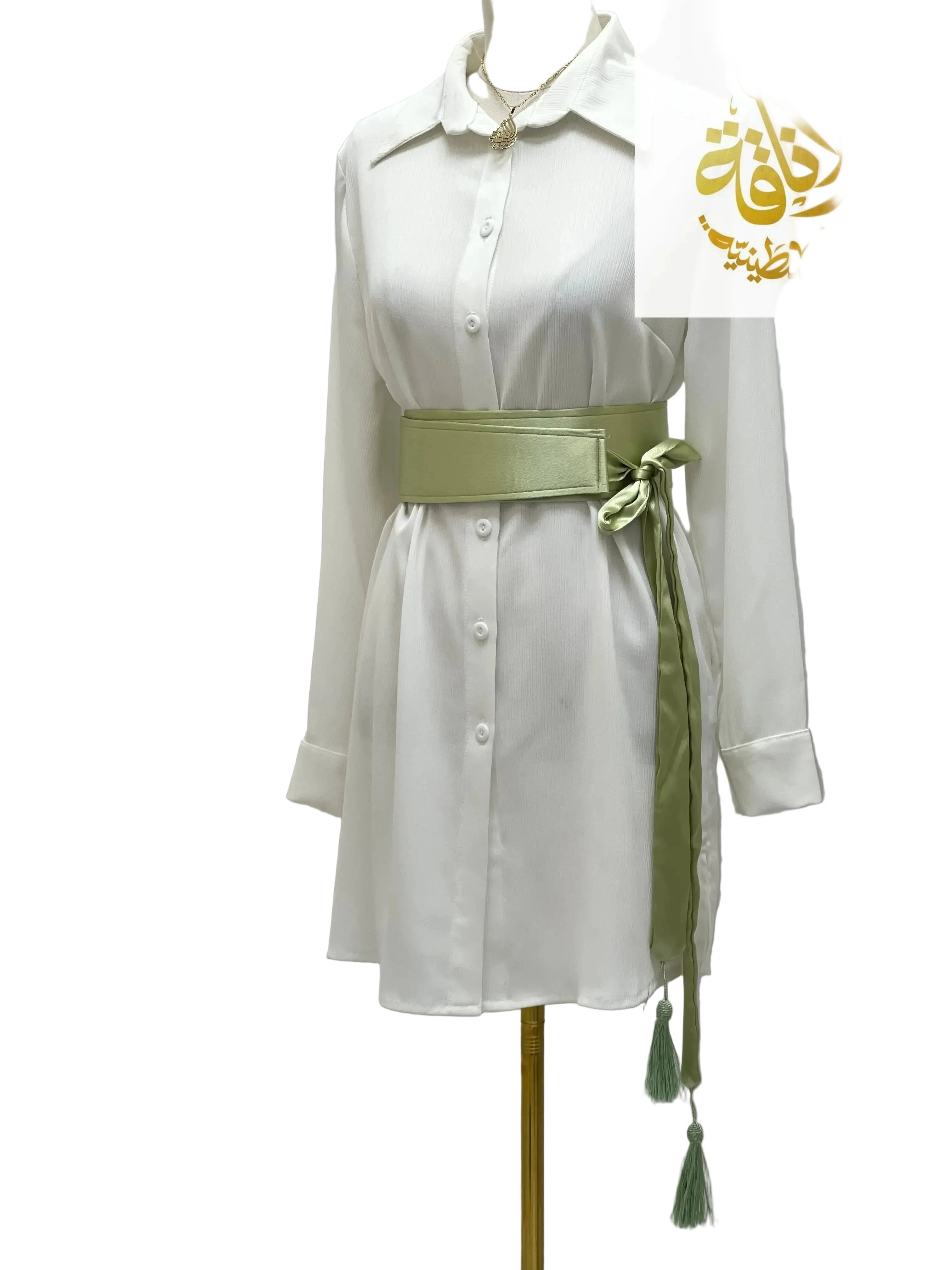 Green satin belt for dresses tied around white button-down shirt dress by Palestinian Elegance
