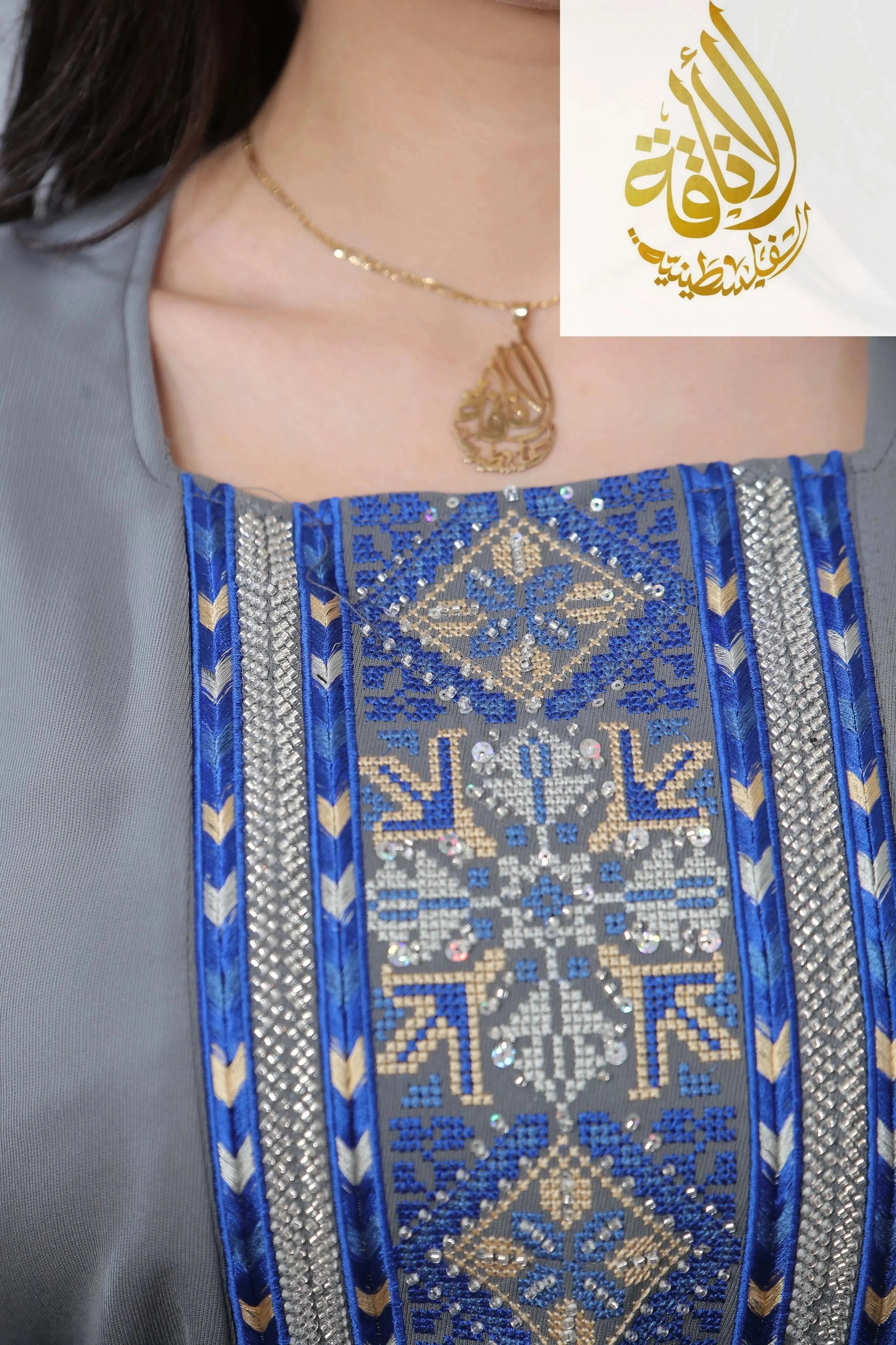 Close-up of Moroccan Rana Jalabia Thoub with intricate blue and beige geometric embroidery from Palestinian Elegance