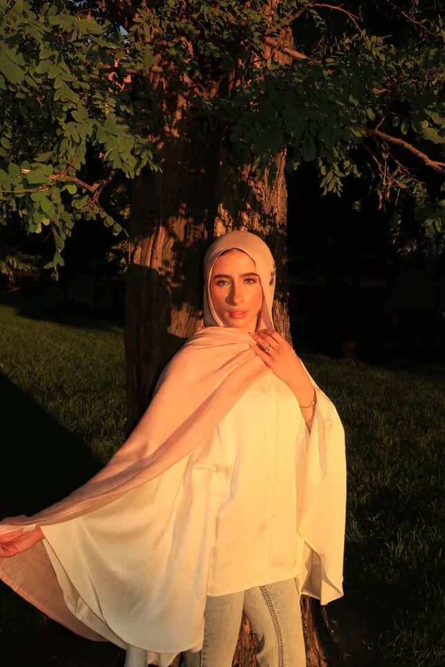 Palestinian Elegance New Modal Hijab light blush drape on woman in golden sunset wearing white tunic and jeans