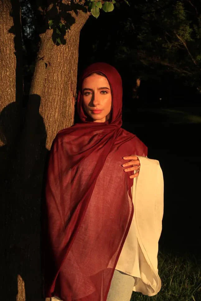 Palestinian Elegance New Modal Hijab deep burgundy draped on woman by tree in warm sunset light