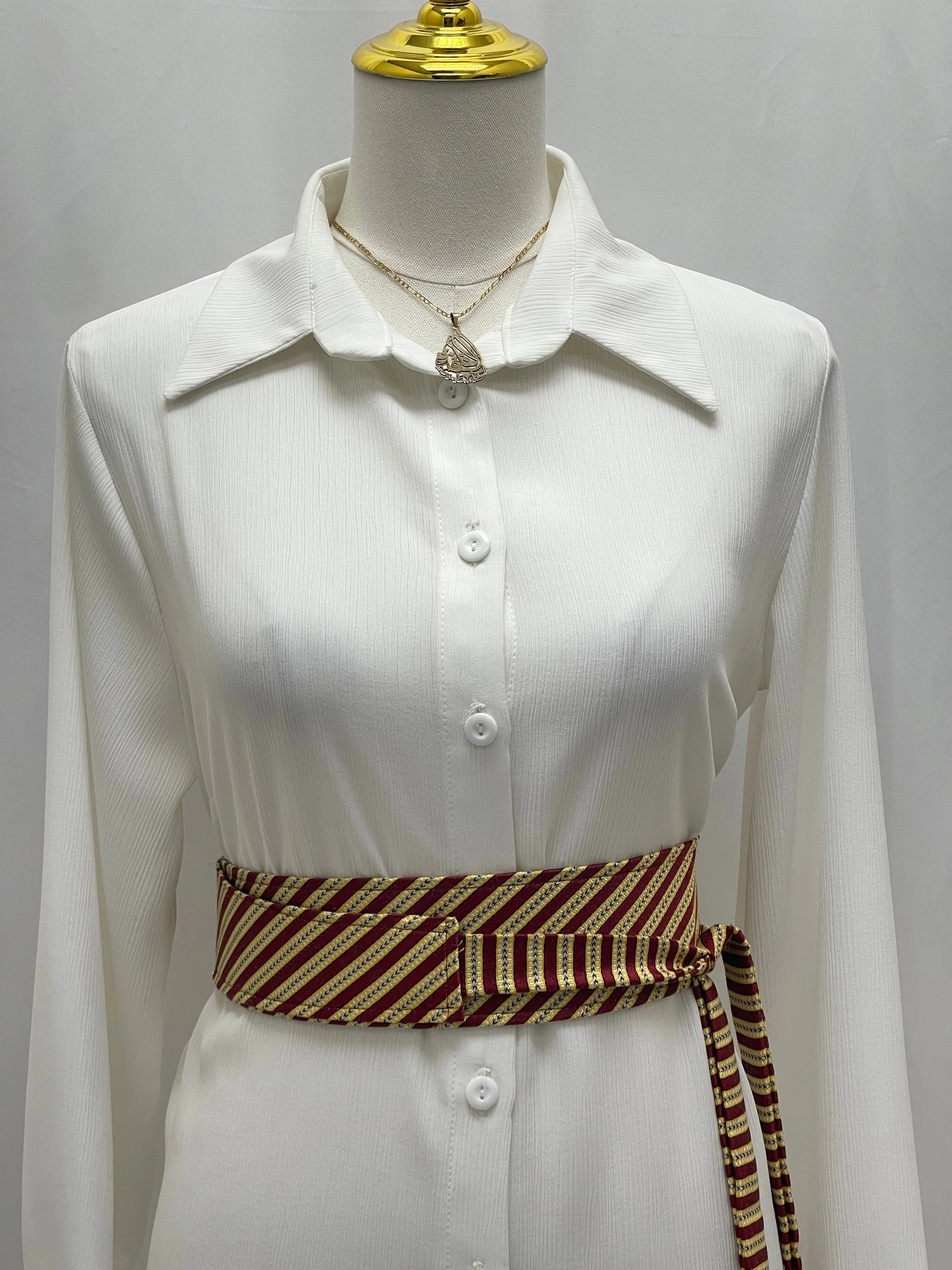 Saya Belt by Palestinian Elegance maroon and gold striped wrap belt styled on white button front dress