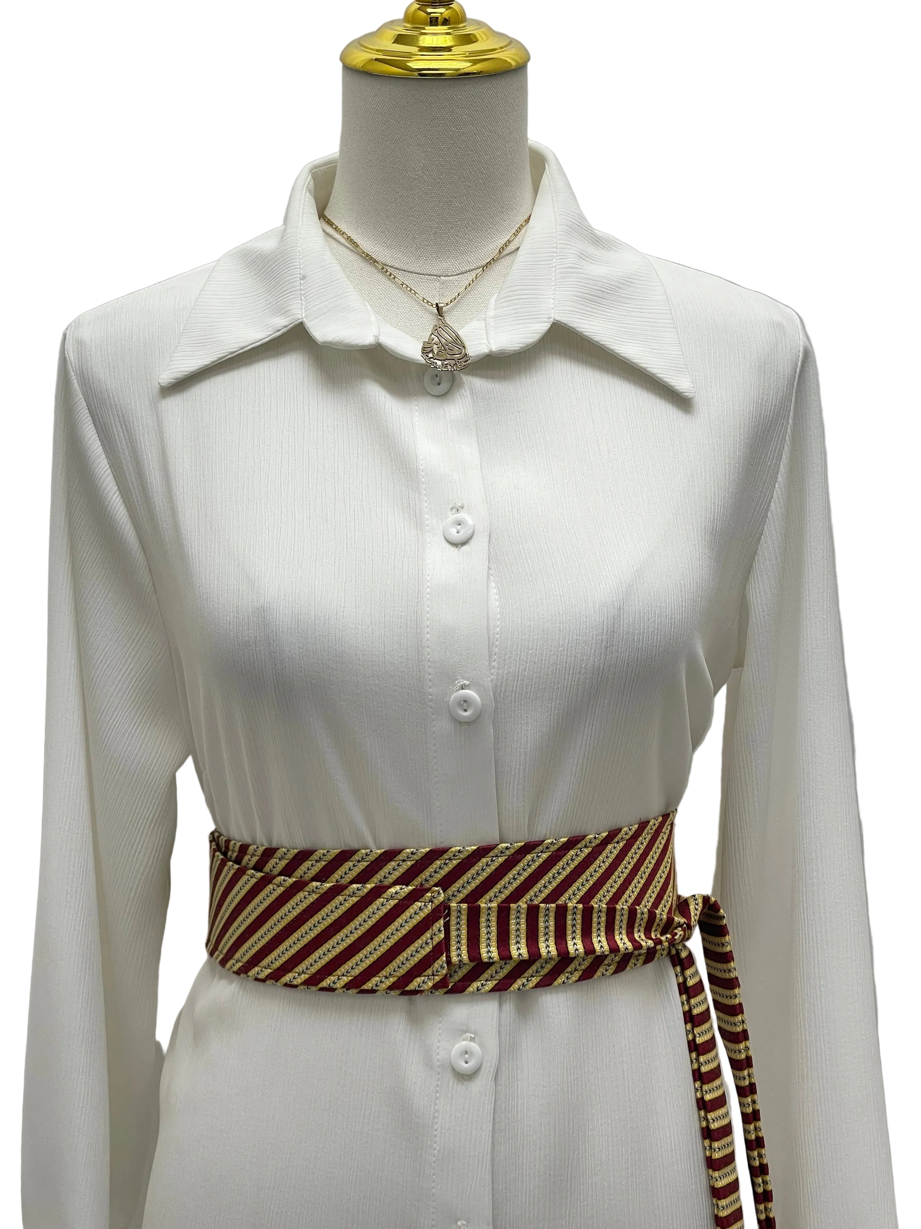 Saya Belt by Palestinian Elegance maroon and gold striped wrap belt styled on white button front dress