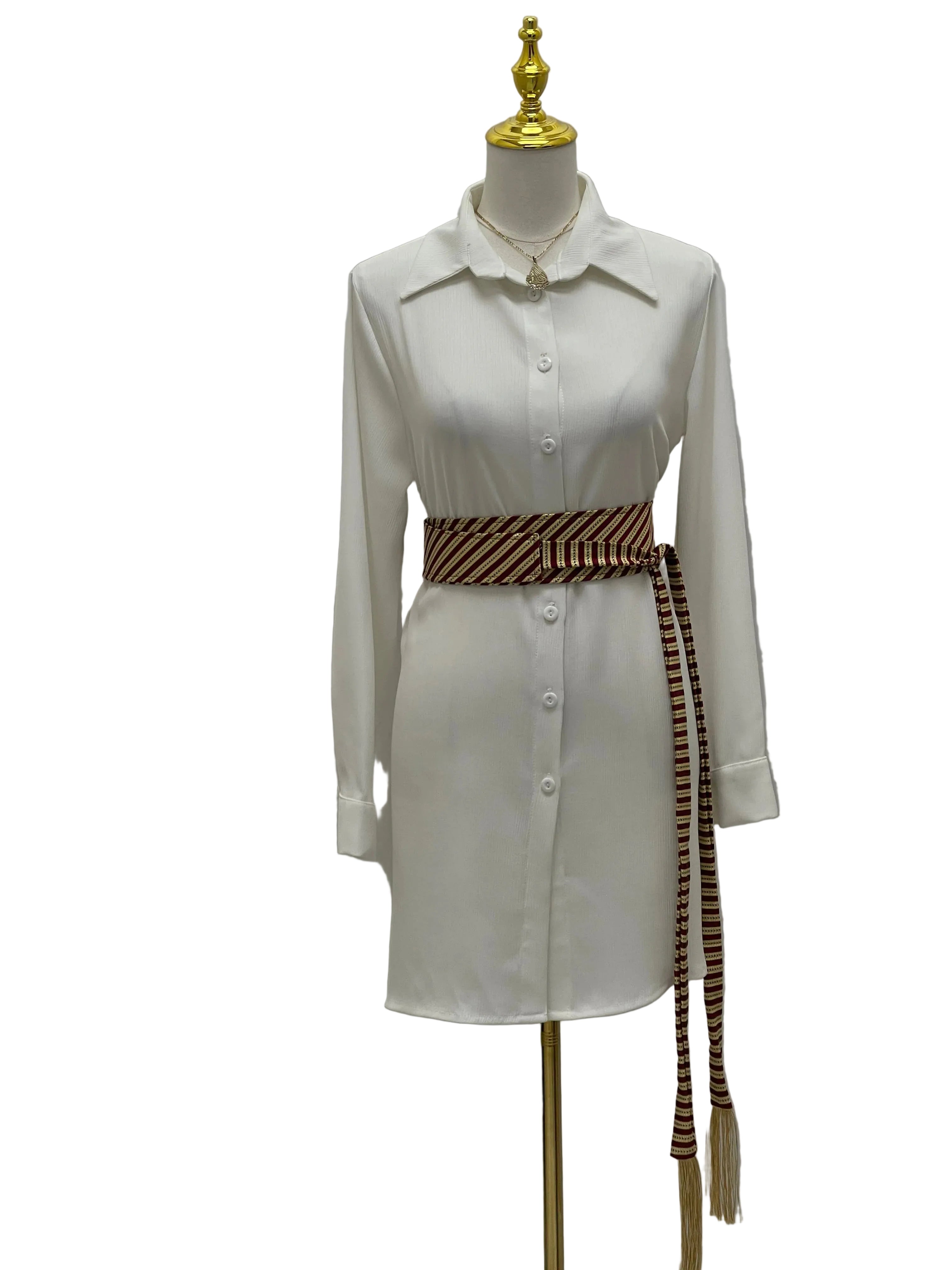 Saya Belt by Palestinian Elegance brown striped woven sash belt with long tassels on white shirt dress