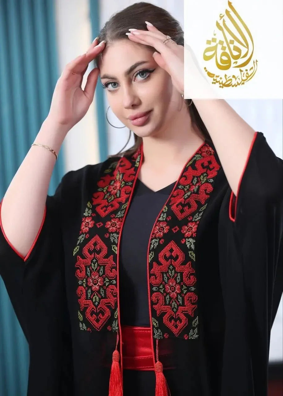Woman wearing embroidered bisht for women with red and green floral patterns by Palestinian Elegance