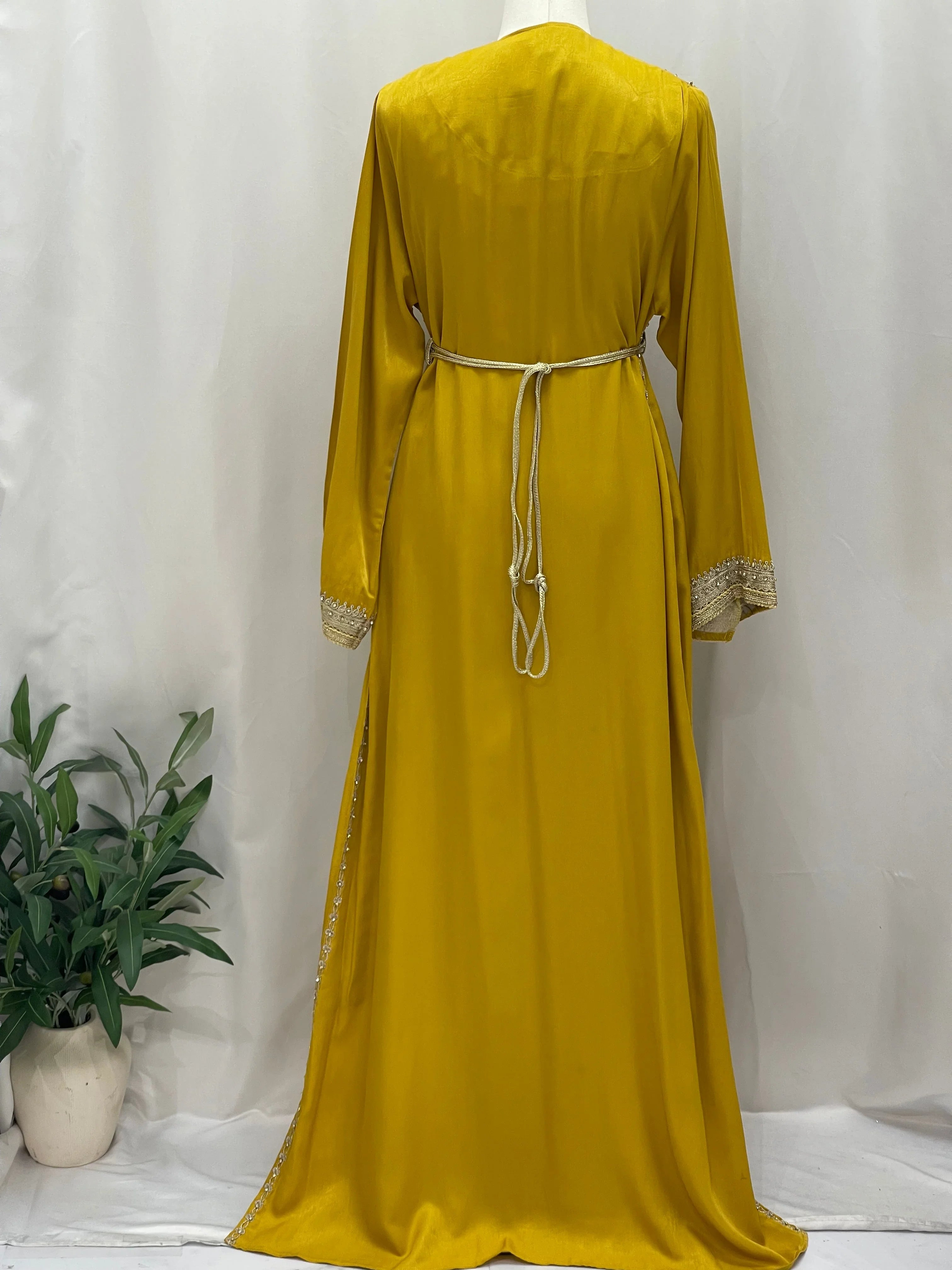 Back view of Omima Morocco Style Kaftan by Palestinian Elegance in mustard yellow with detailed sleeves and waist tie