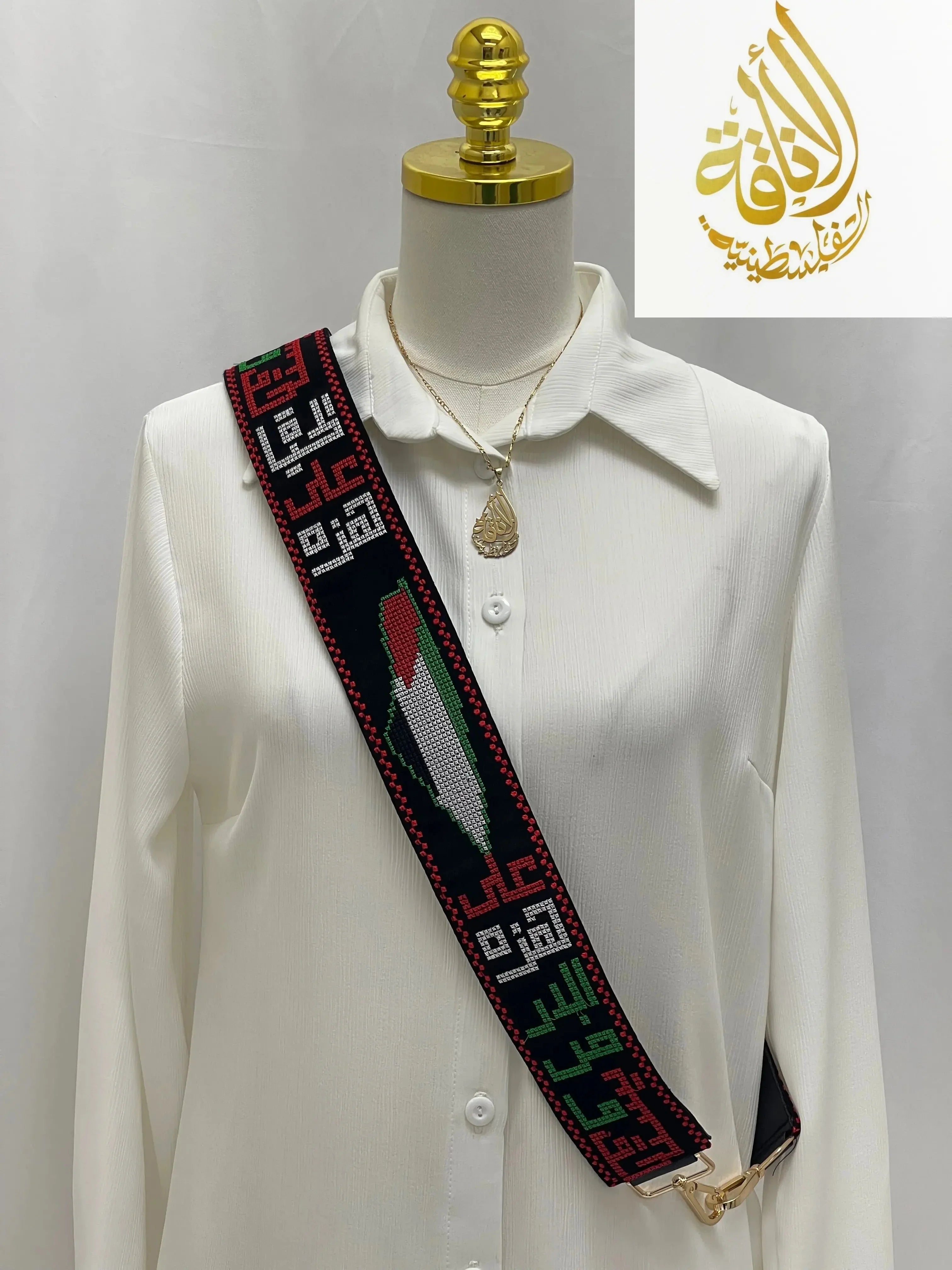 Palestinian Elegance black purse strap with colorful embroidery and Arabic design on white shirt