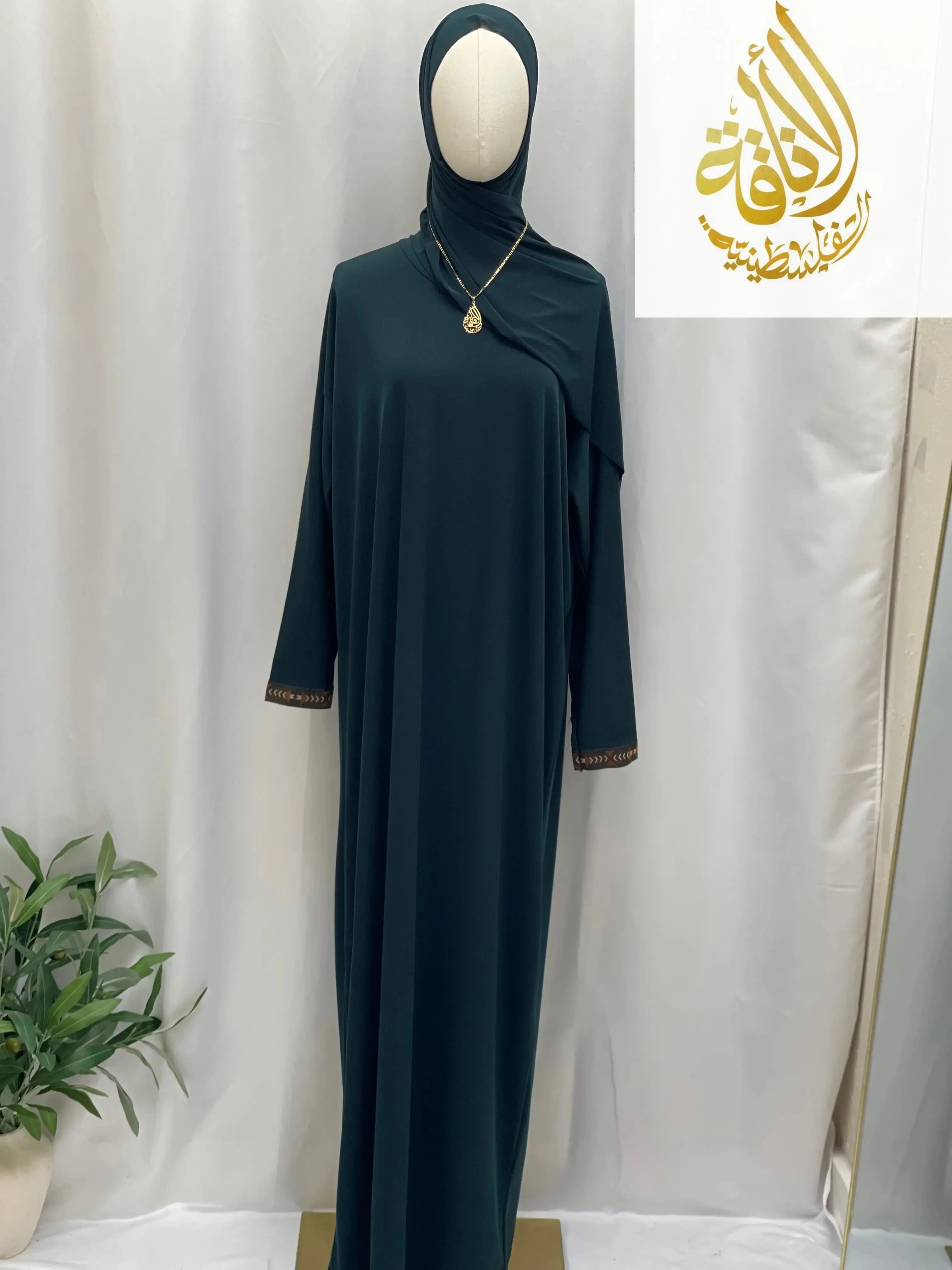 Palestinian Elegance dark green one piece prayer dress abaya with long sleeves and gold trim on cuffs