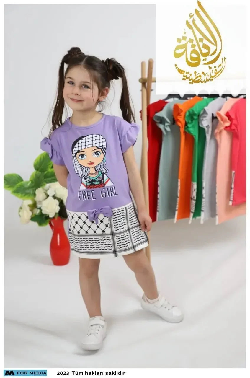 Free Kofya Dress for girls in purple worn by a smiling girl with multiple dresses on a rack in the background
