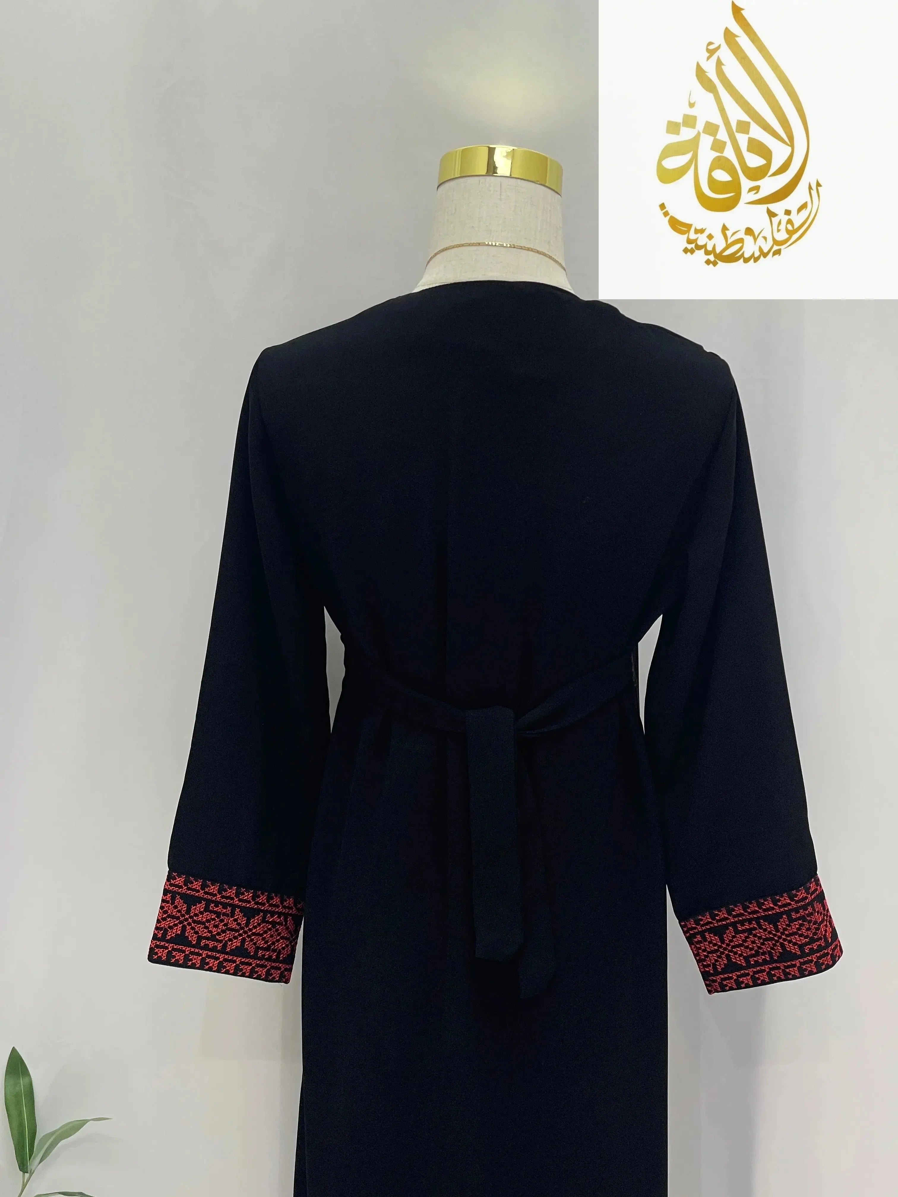 Back view of Kid's Haya Embroidered Abaya by Palestinian Elegance with red embroidery on black fabric sleeves
