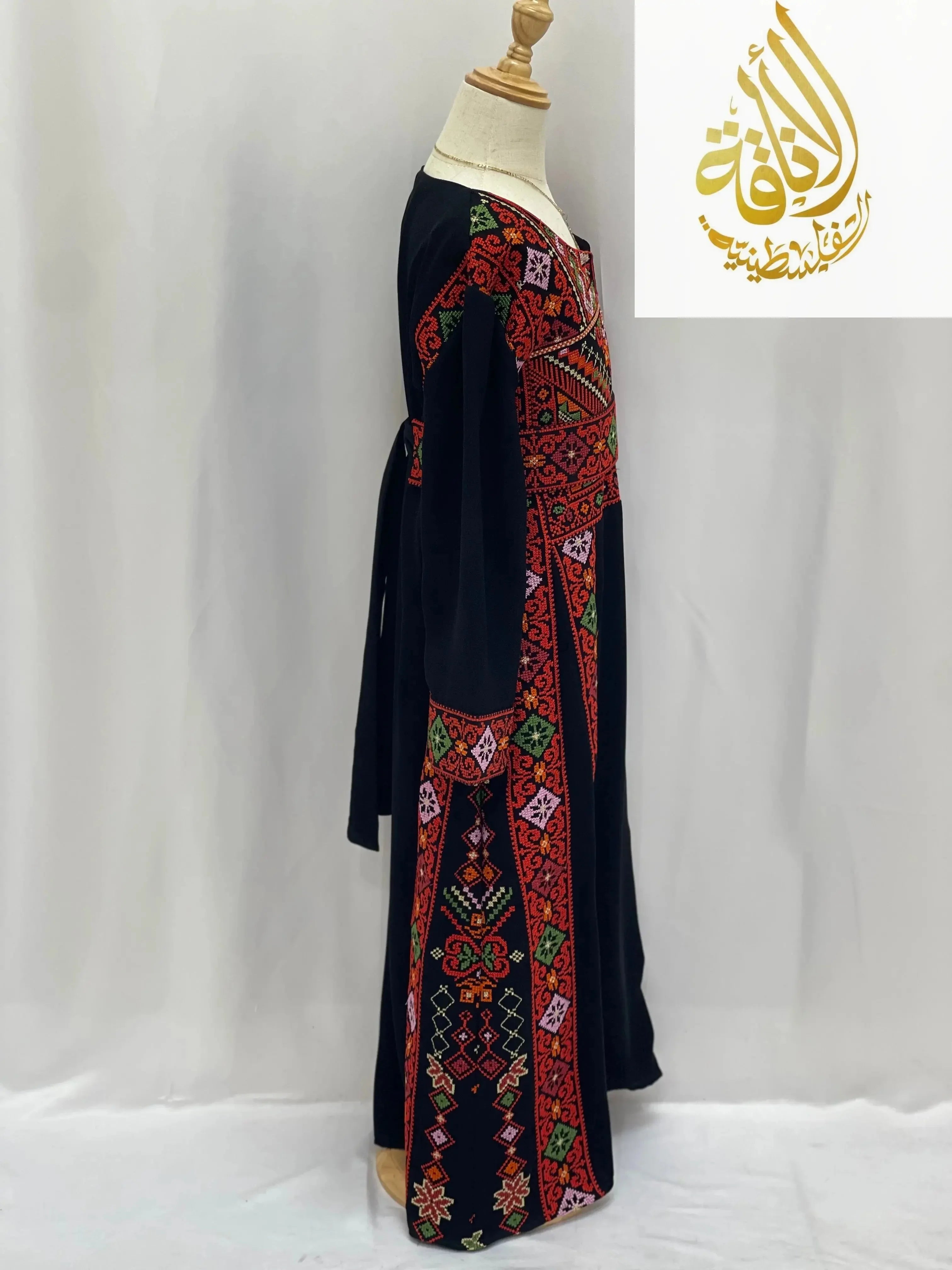 Black embroidered thoub for girls with vibrant red and green traditional Palestinian patterns