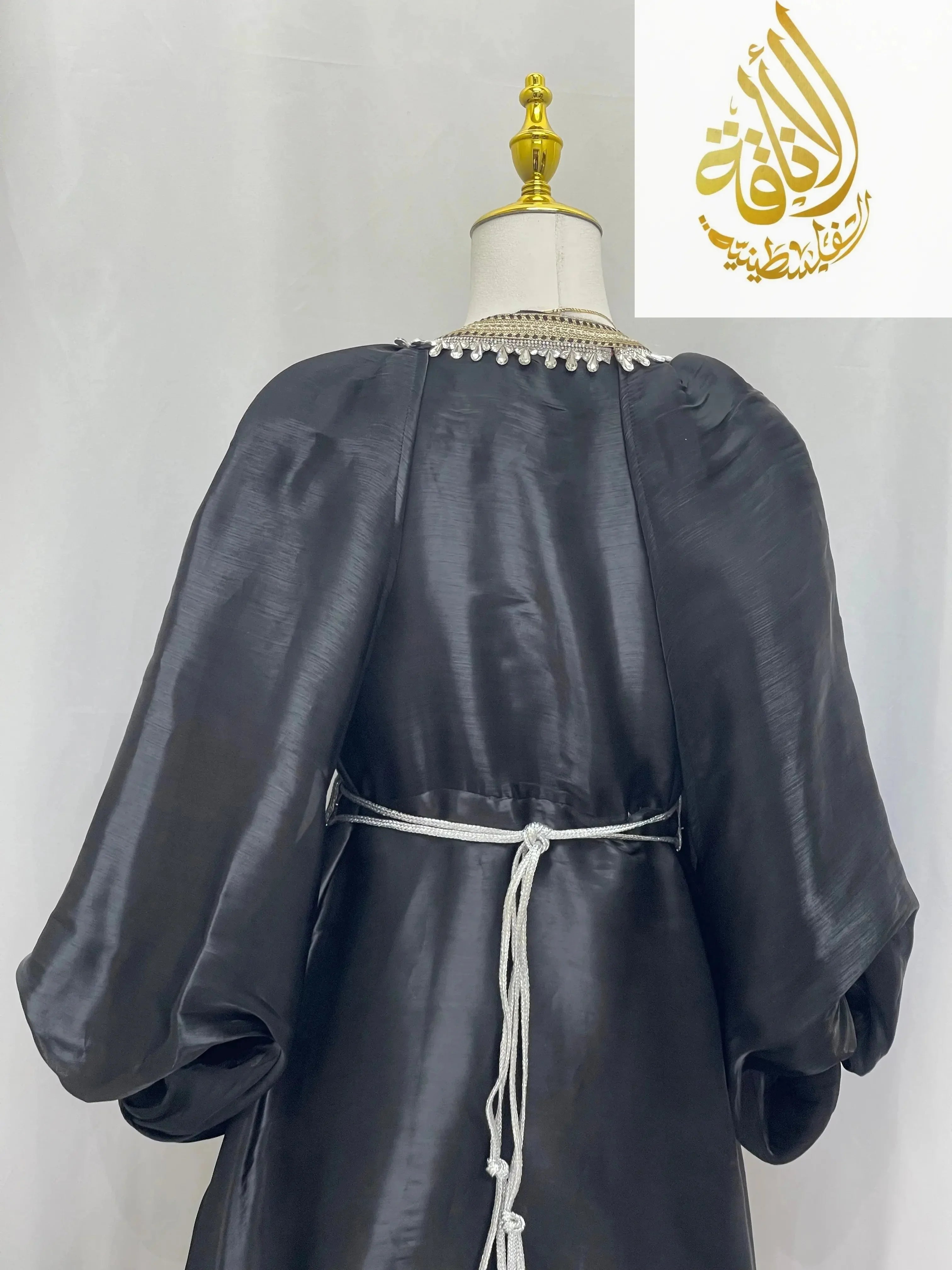 Black puffy sleeves kaftan dress with a silver belt and decorative neckline by Palestinian Elegance