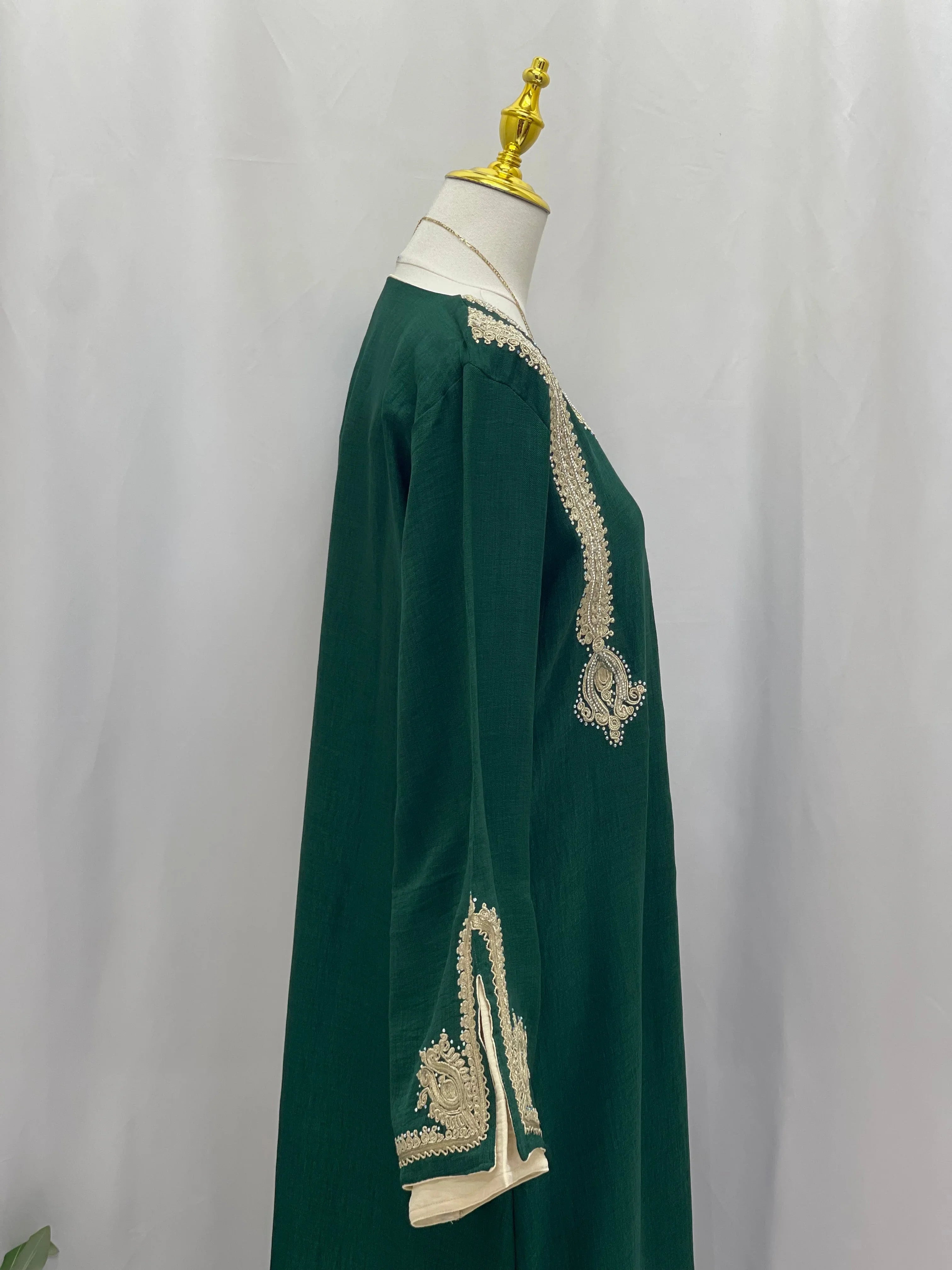 Regal Moroccan Jalabiya green embroidered long sleeve on mannequin by Palestinian Elegance with beige trim
