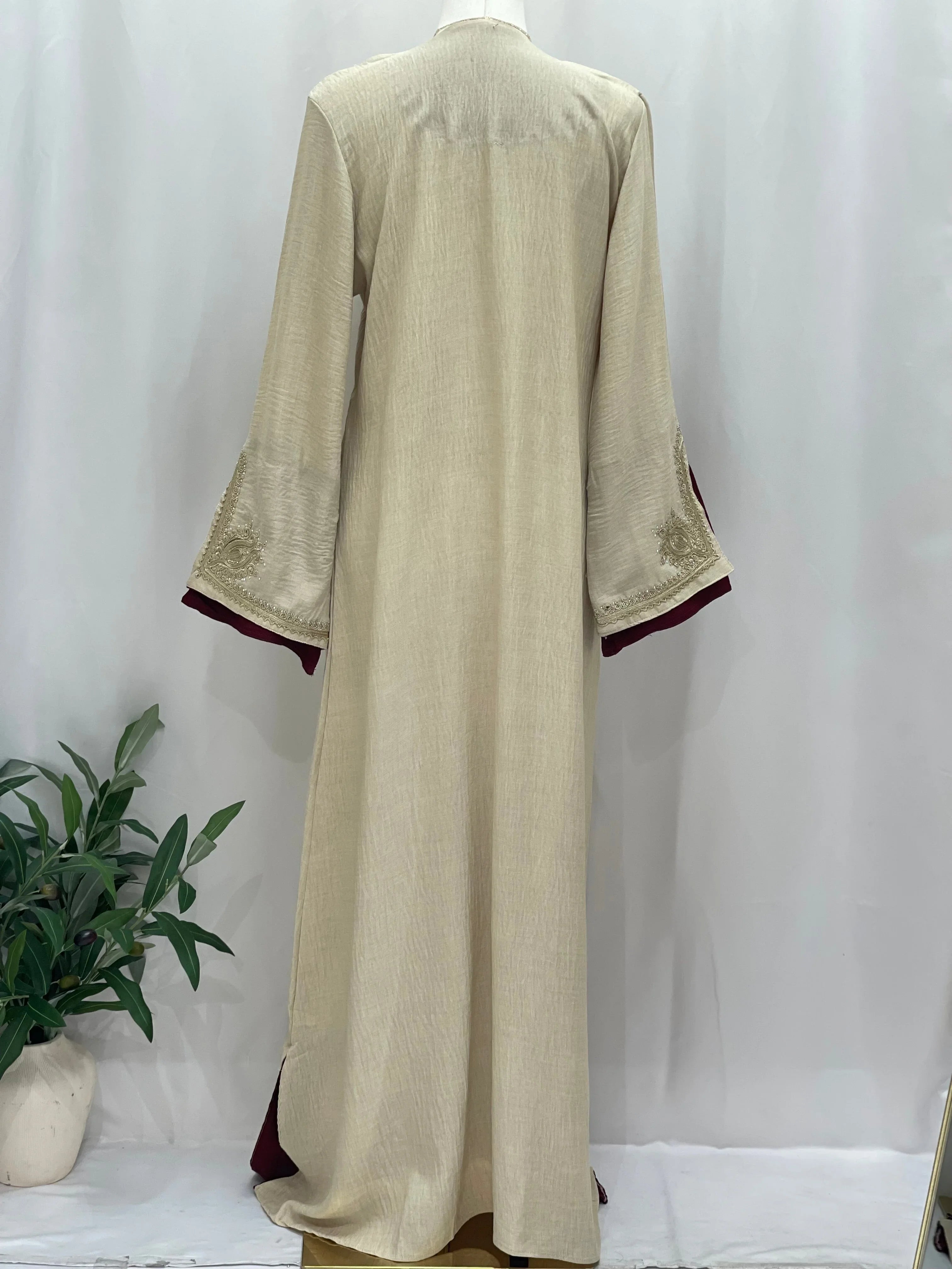 Regal Moroccan Jalabiya by Palestinian Elegance beige back view long sleeves maroon trim embroidered cuffs