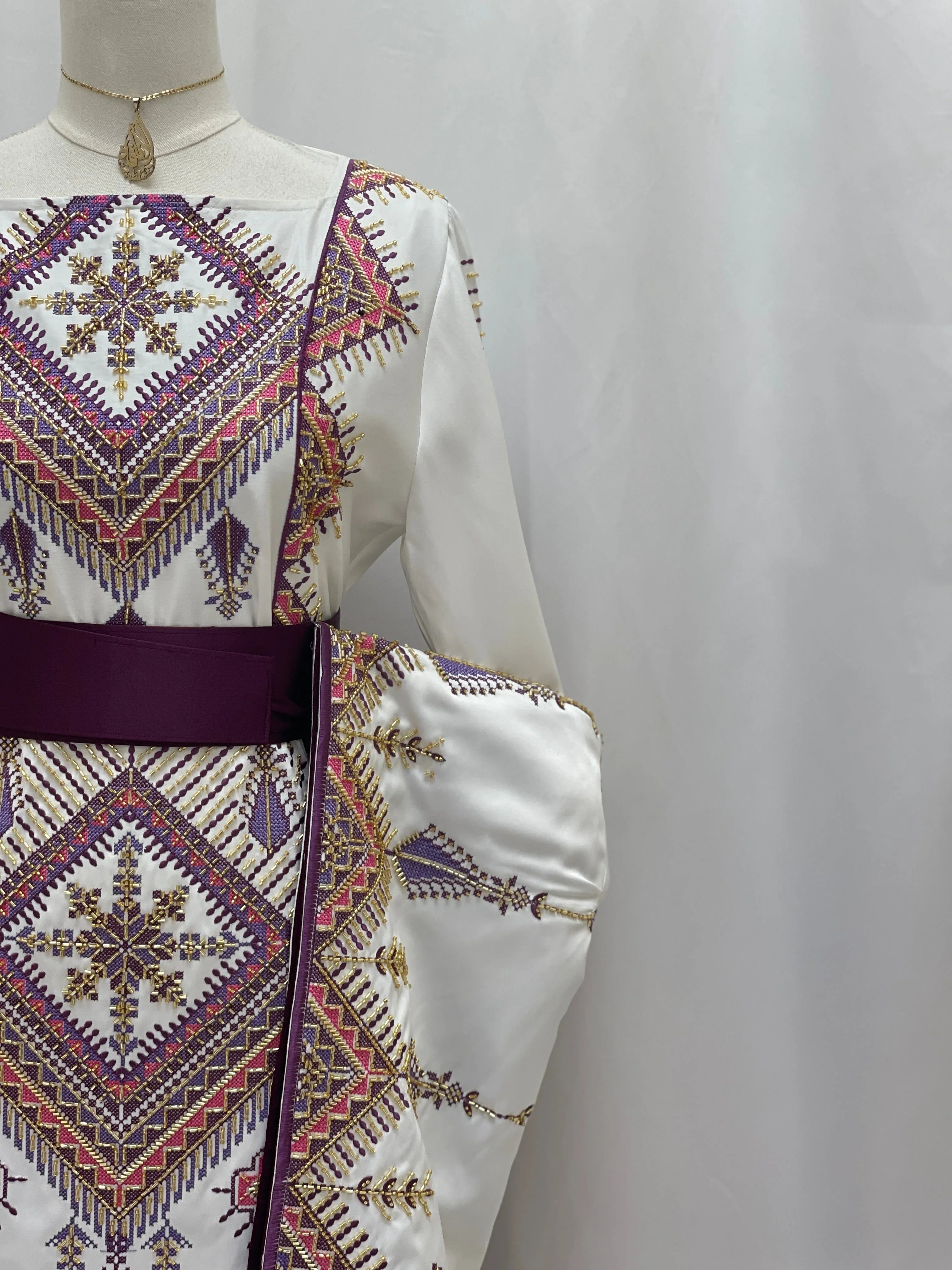 Palestinian Elegance Embroidered Thoub Gown white bridal dress with purple and gold geometric embroidery and a wide sash belt