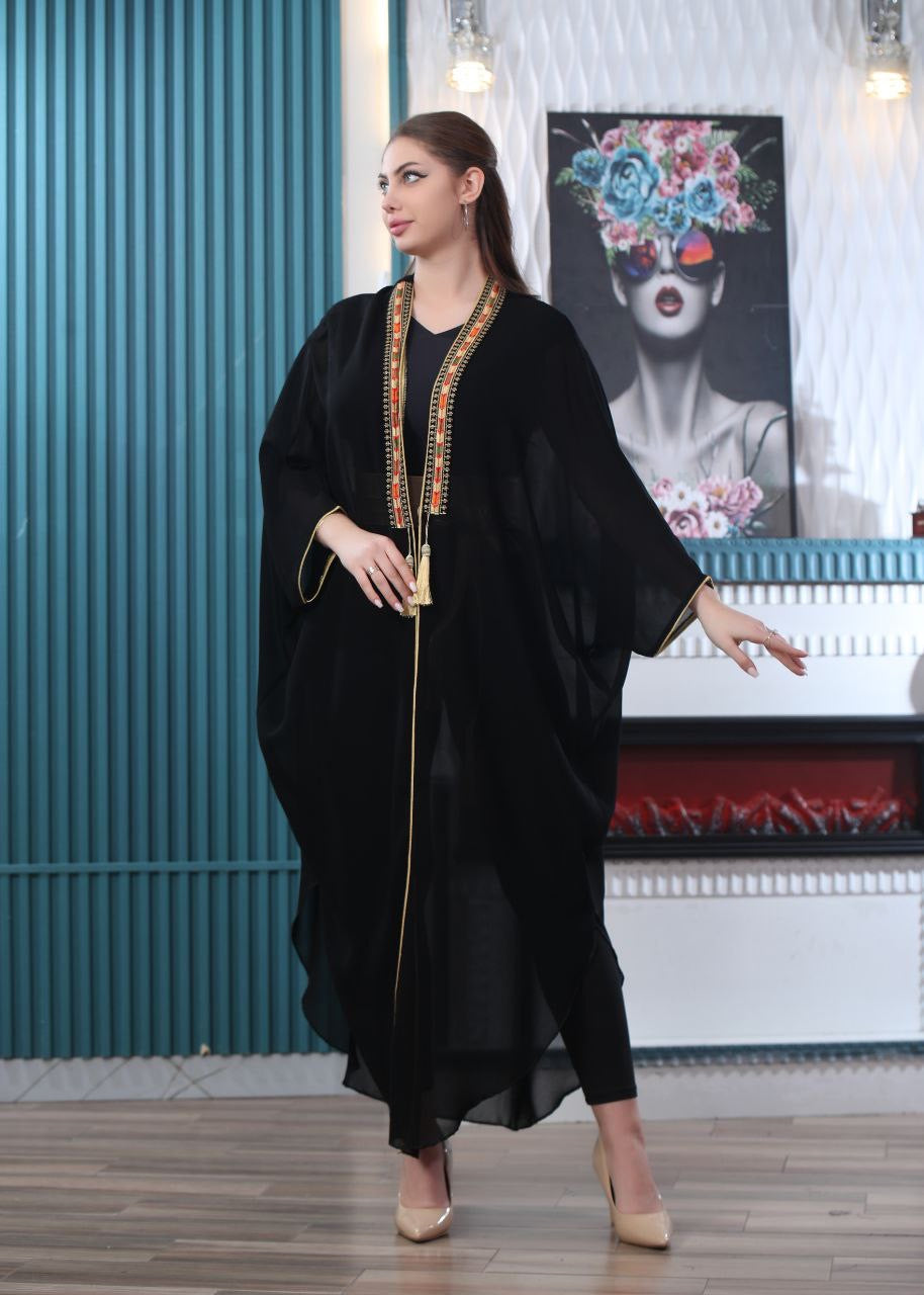 Black embroidered chiffon cardigan from Palestinian Elegance worn by woman in stylish indoor setting