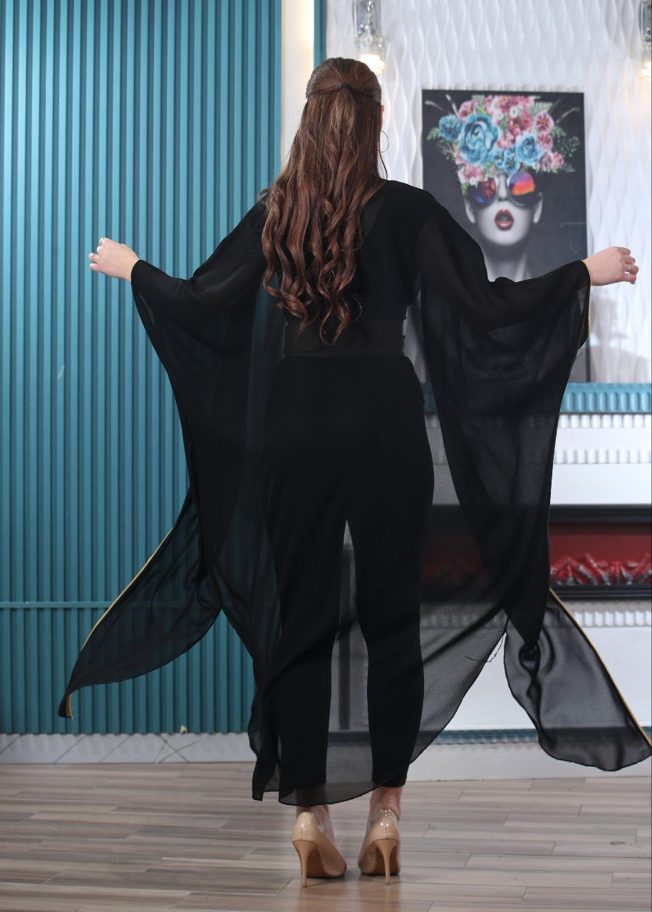 Back view of woman wearing black embroidered chiffon cardigan with flowing sleeves by Palestinian Elegance