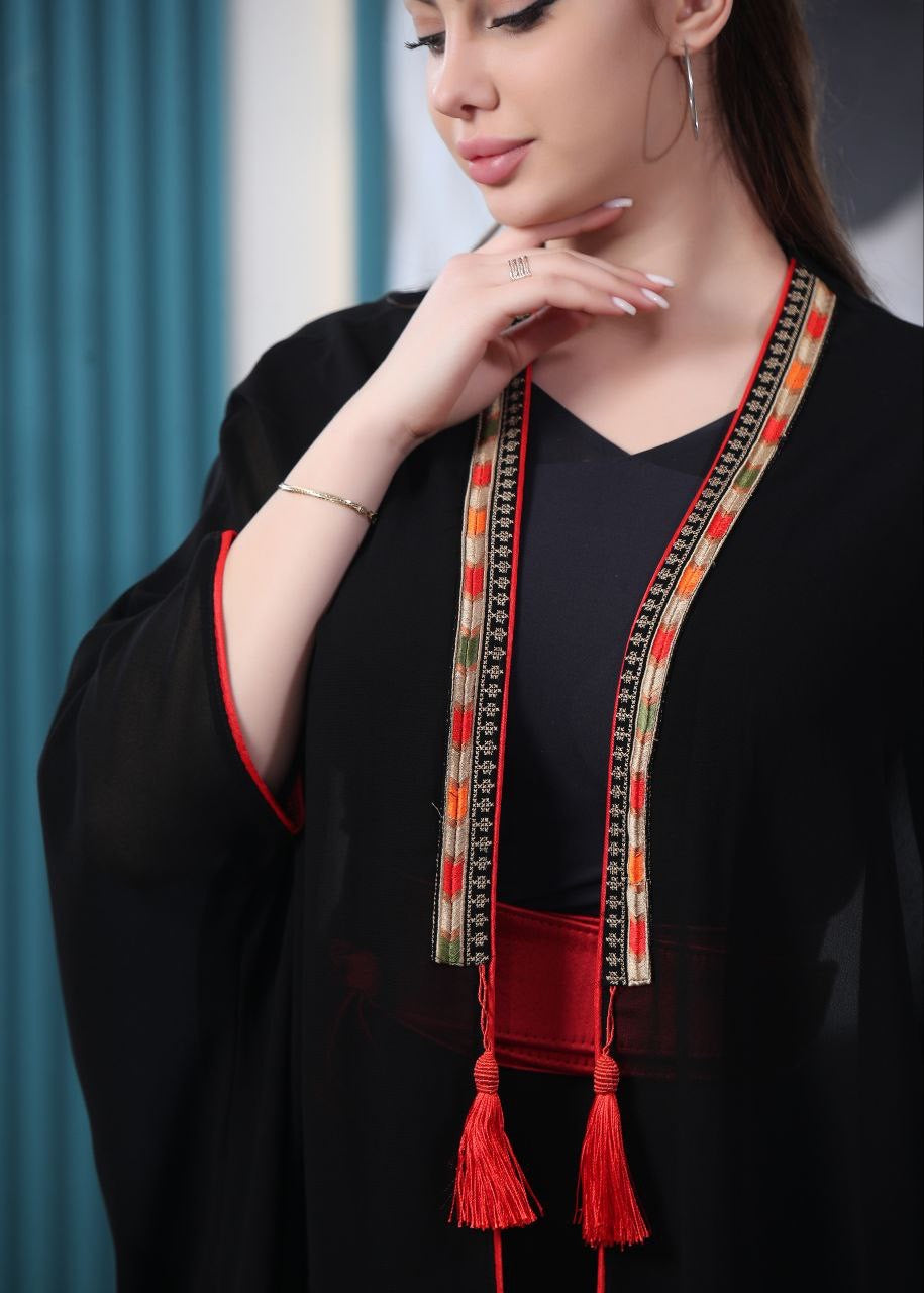 Black embroidered chiffon cardigan from Palestinian Elegance with red tassel details and colorful embroidery
