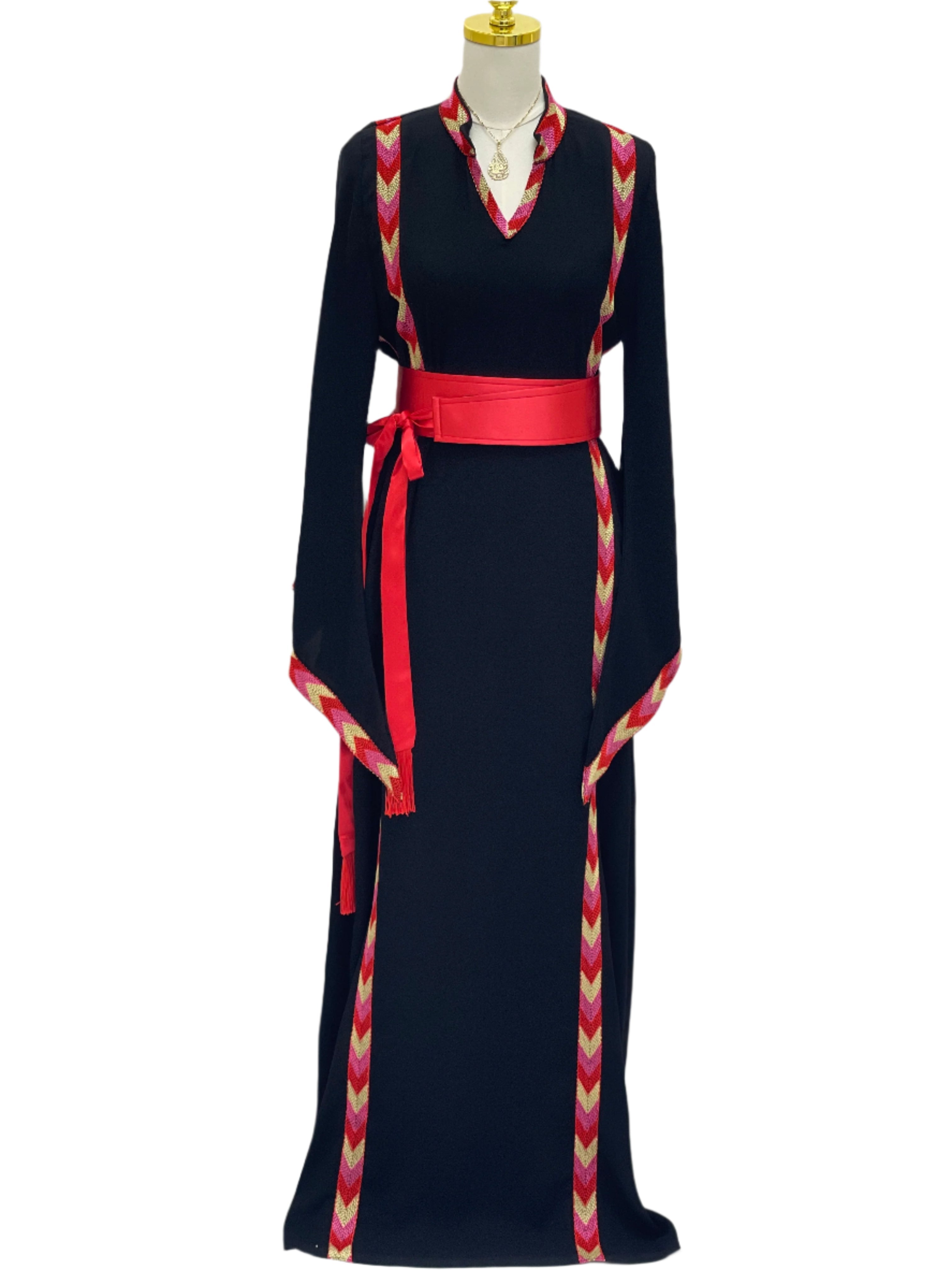Black embroidered thoub dress with red patterned trim and a red waist belt by Palestinian Elegance