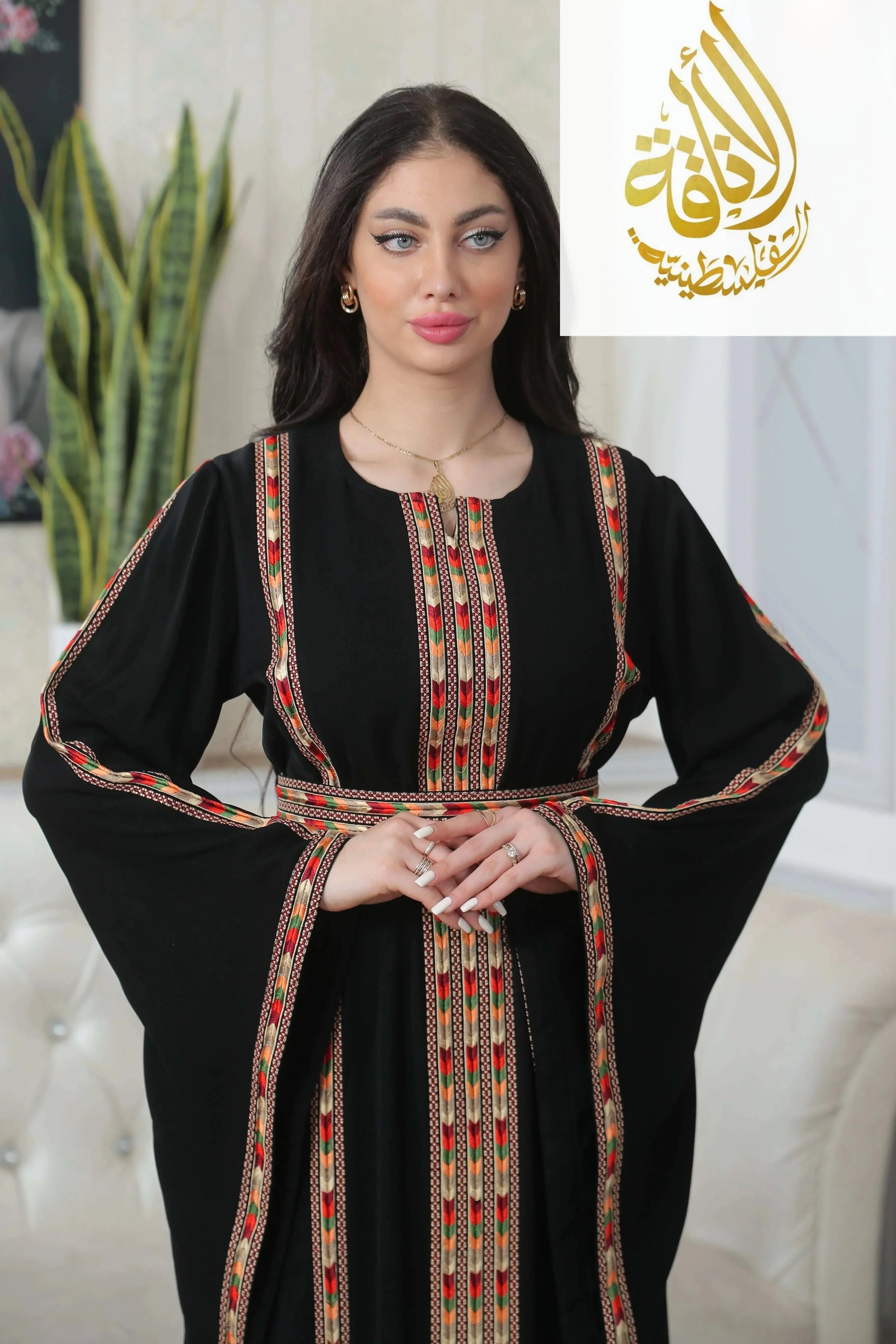 Palestinian Elegance Salam Manjal Embroidered Thoub in black with intricate red and gold embroidery details