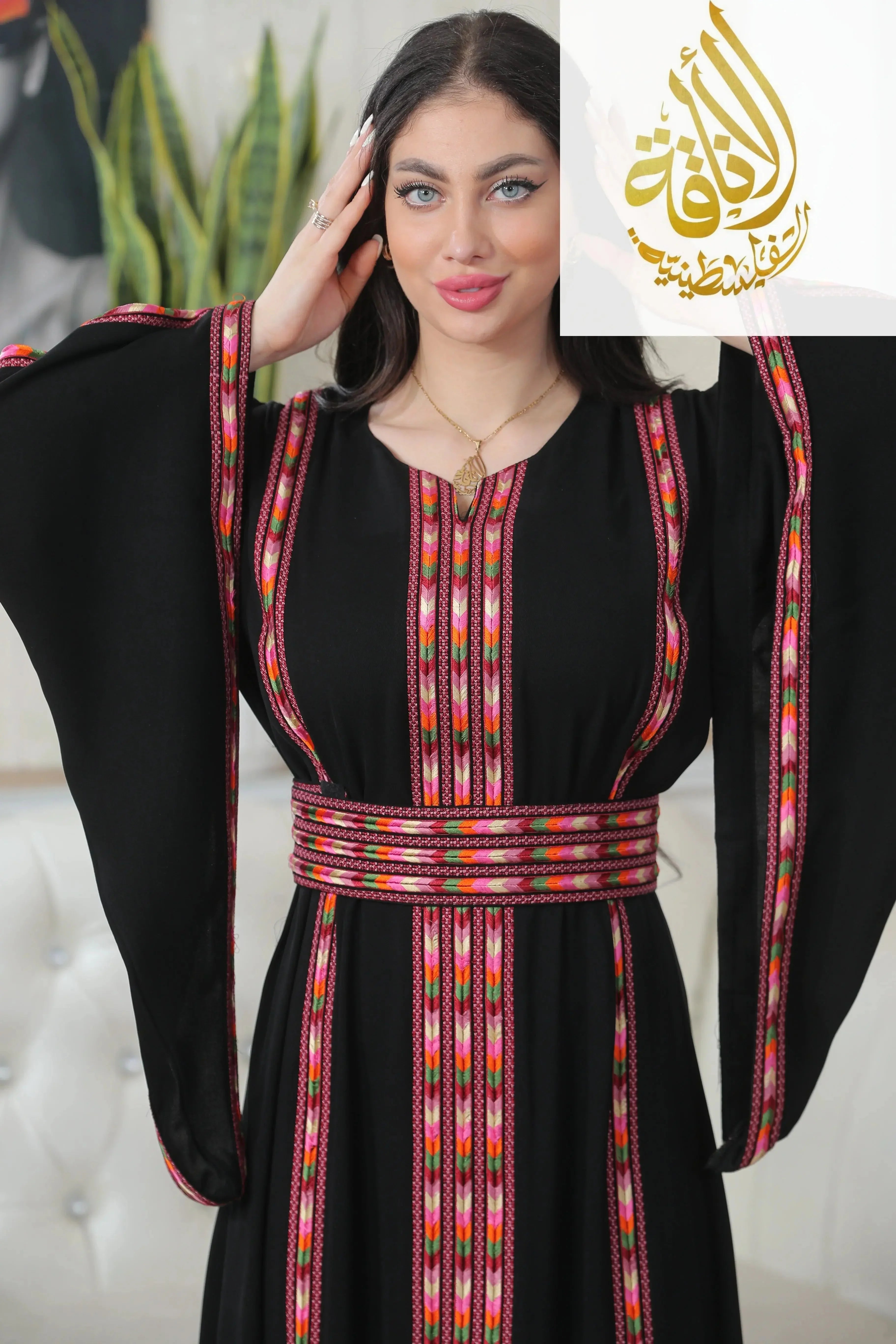 Palestinian Elegance Salam Manjal Embroidered Thoub in black with vibrant traditional pink and red embroidery