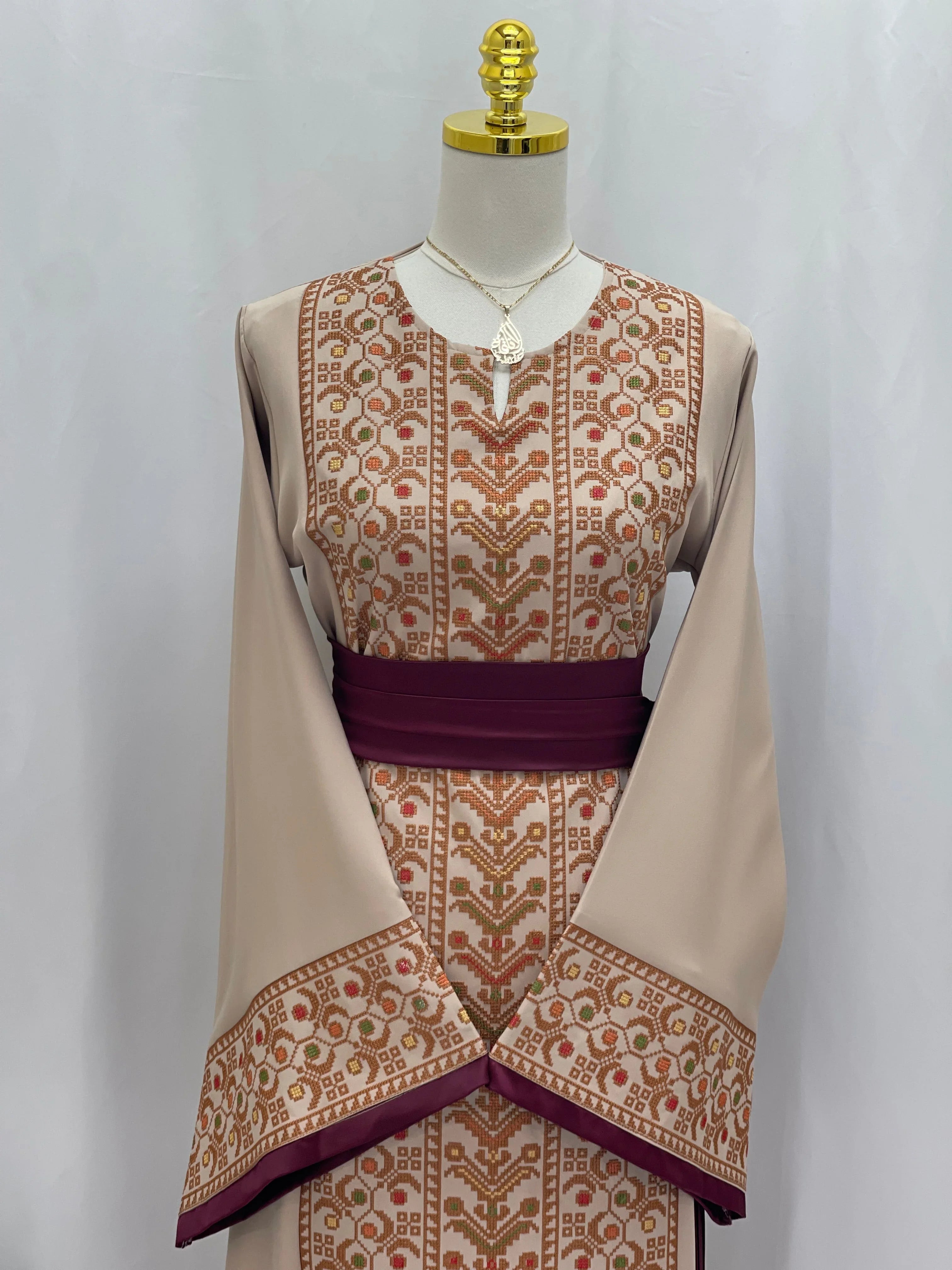 Palestinian Elegance Embroiderd Thobe With Belt in beige with intricate brown and rust embroidery and a dark purple belt