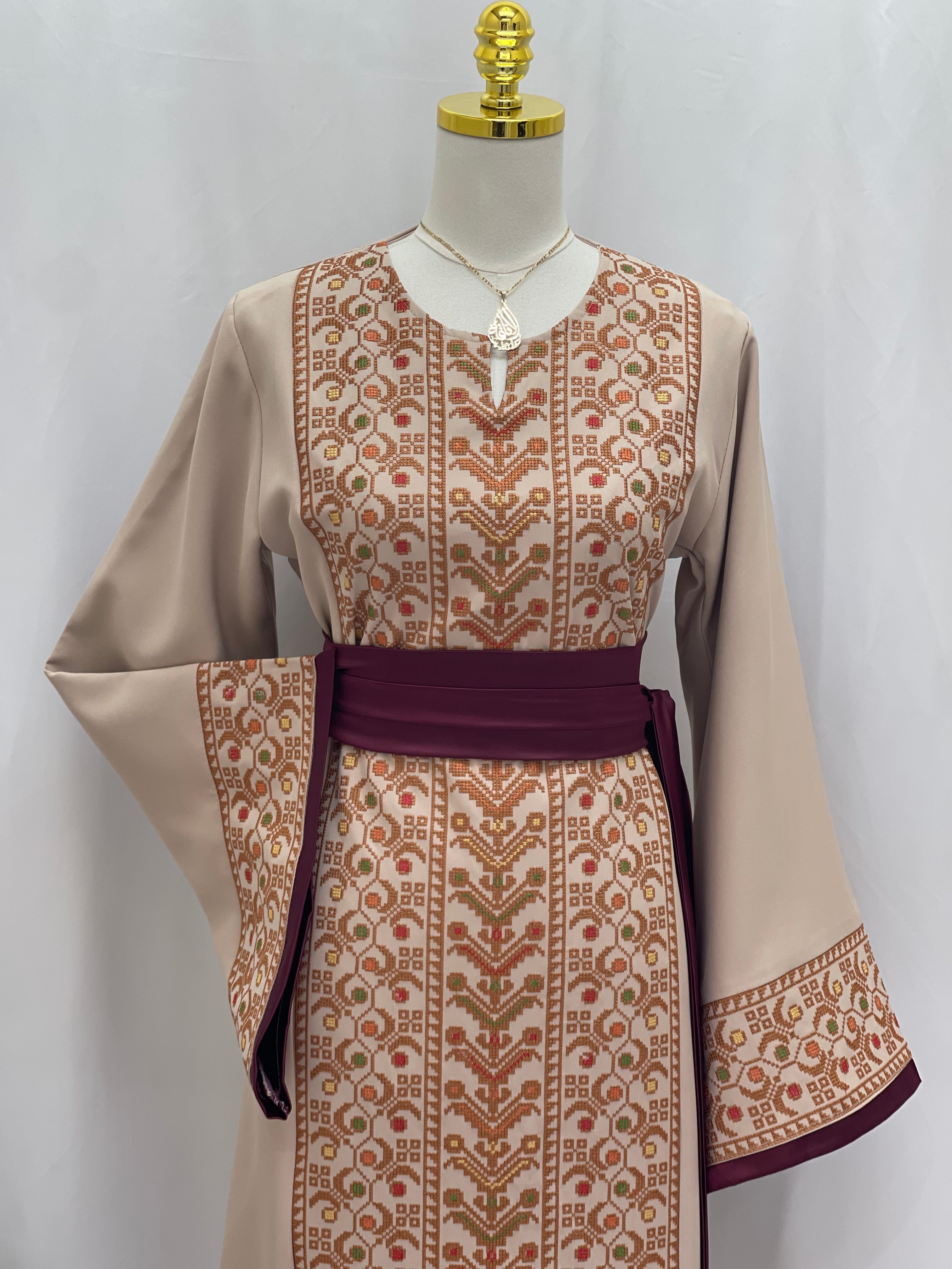 Palestinian Elegance Embroiderd Thobe With Belt in beige with intricate traditional embroidery and purple belt