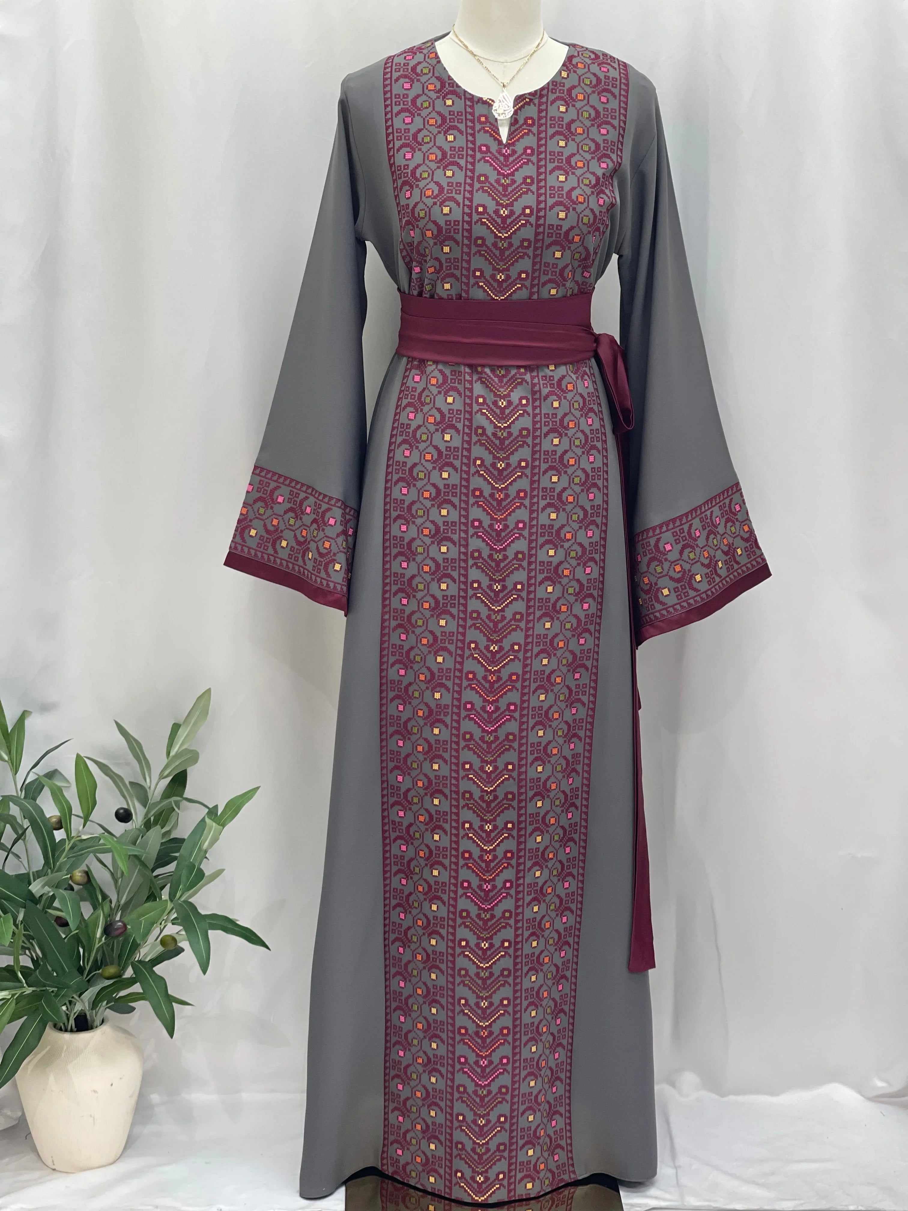 Palestinian Elegance Embroiderd Thobe With Belt in gray with detailed pink embroidery on front and sleeves