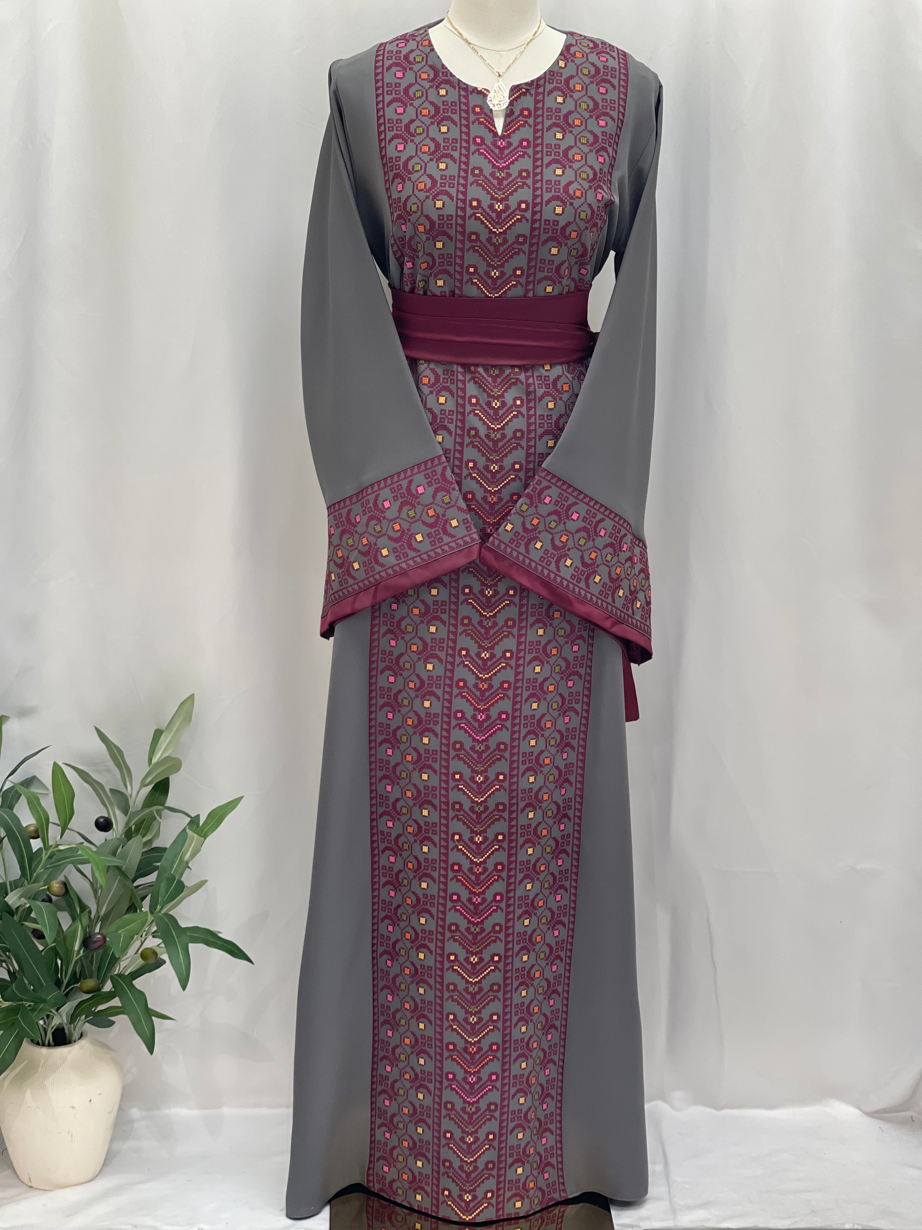 Palestinian Elegance Embroiderd Thobe With Belt featuring intricate maroon and gold embroidery on gray fabric