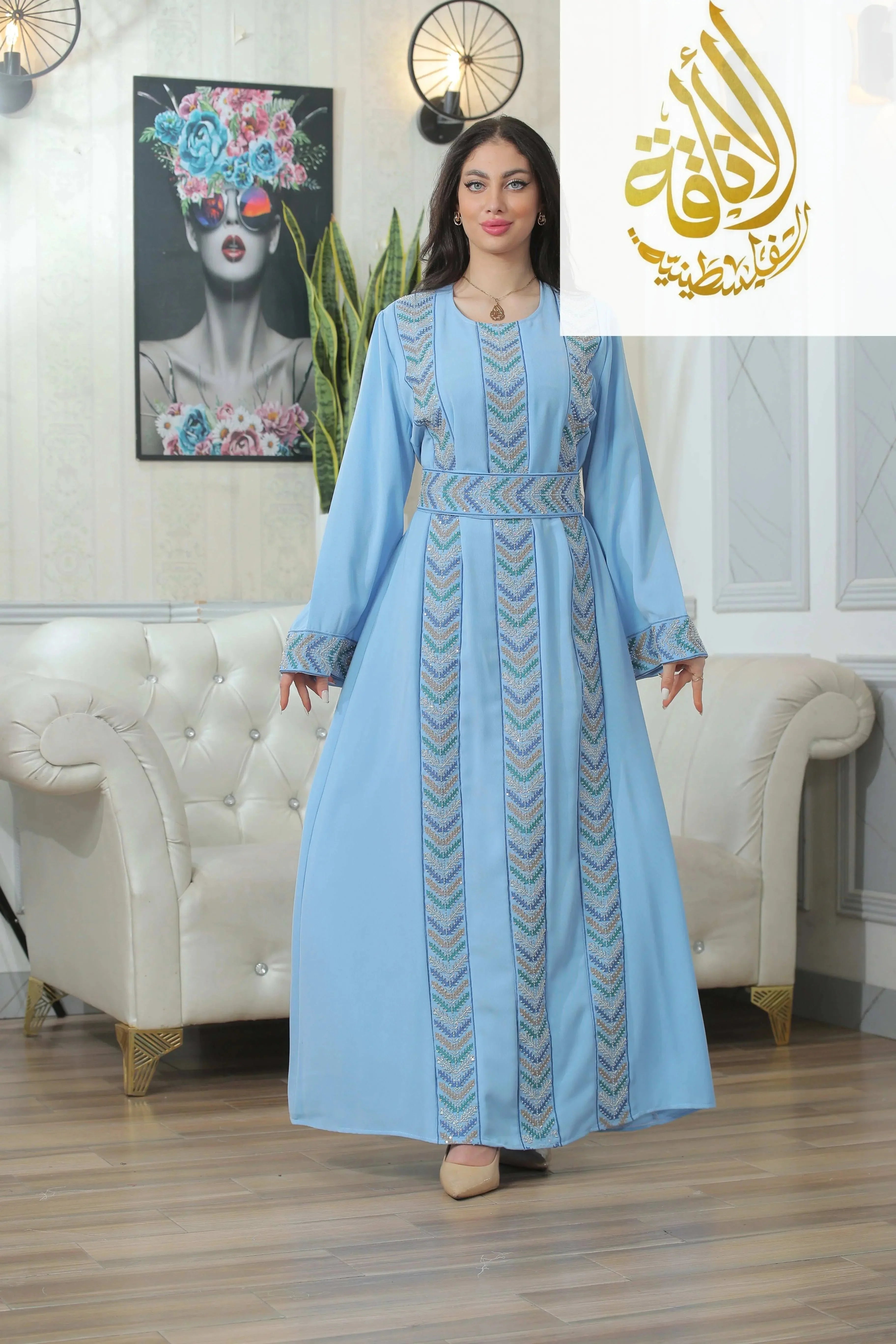 Woman wearing light blue Seham Embroidered Beads Thoub with geometric patterns from Palestinian Elegance