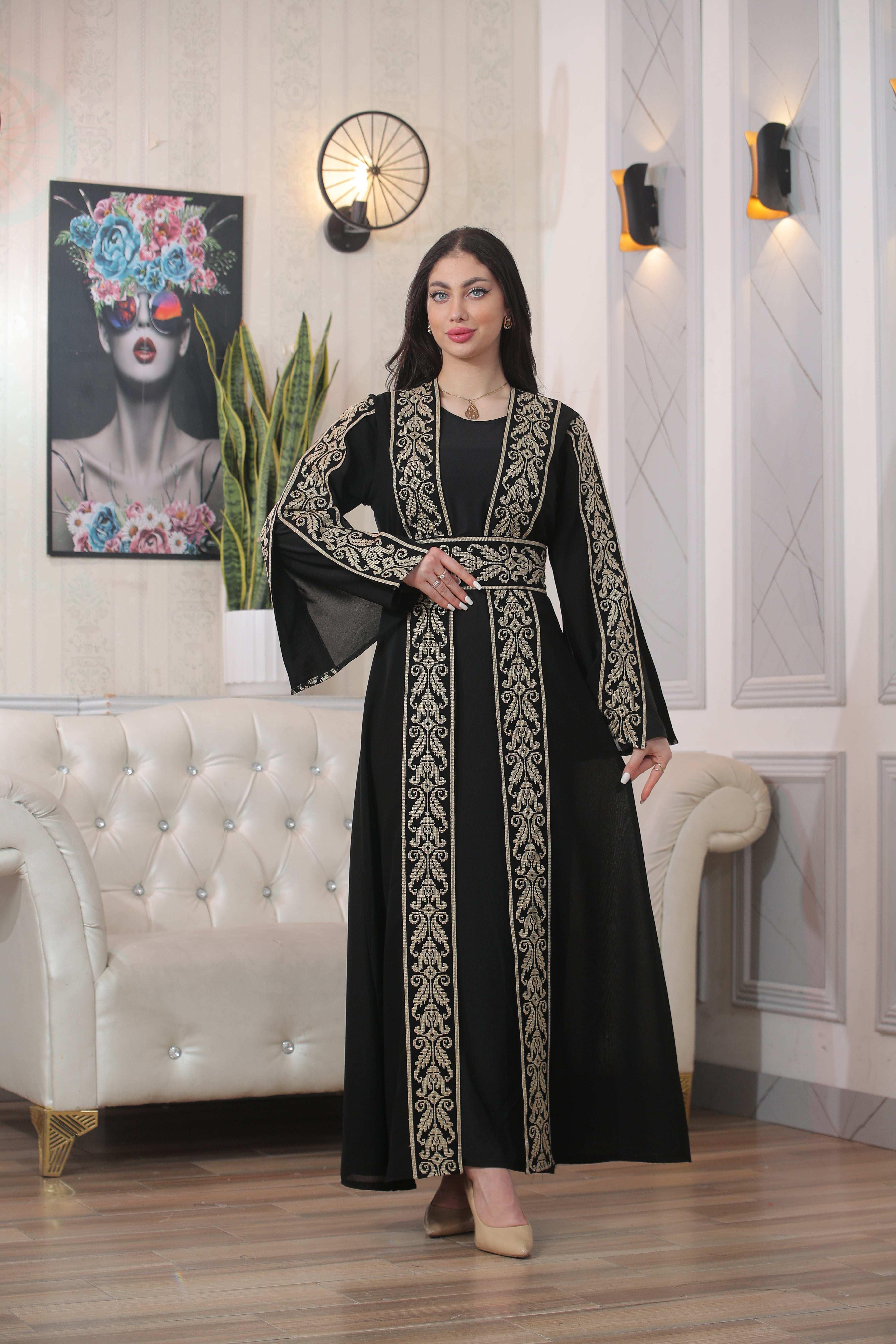 Woman wearing Shereen Embroidered Bisht Abaya black thoub with intricate gold embroidery from Palestinian Elegance