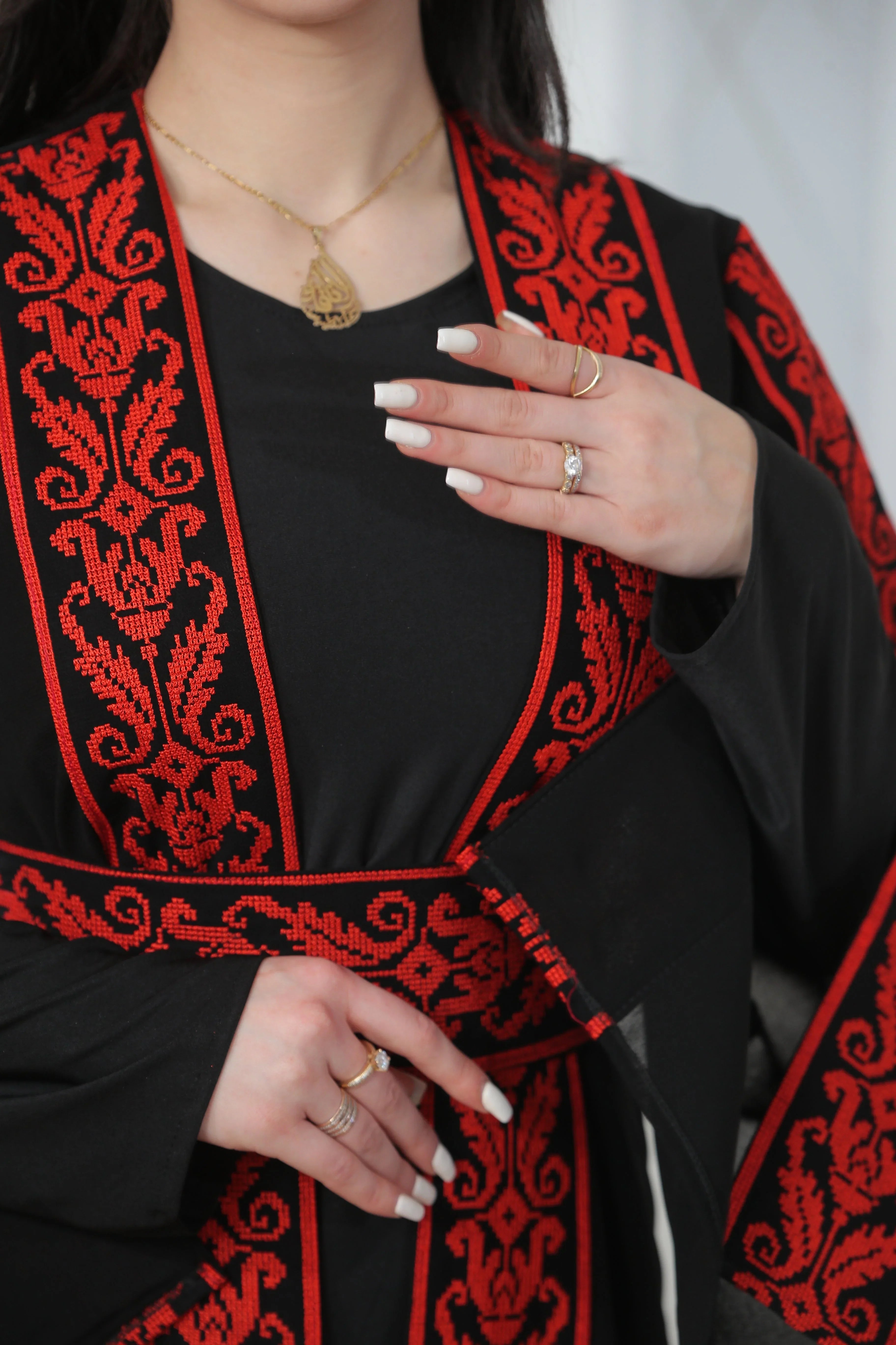 Shereen Embroidered Bisht Abaya by Palestinian Elegance featuring intricate red embroidery on black thoub fabric