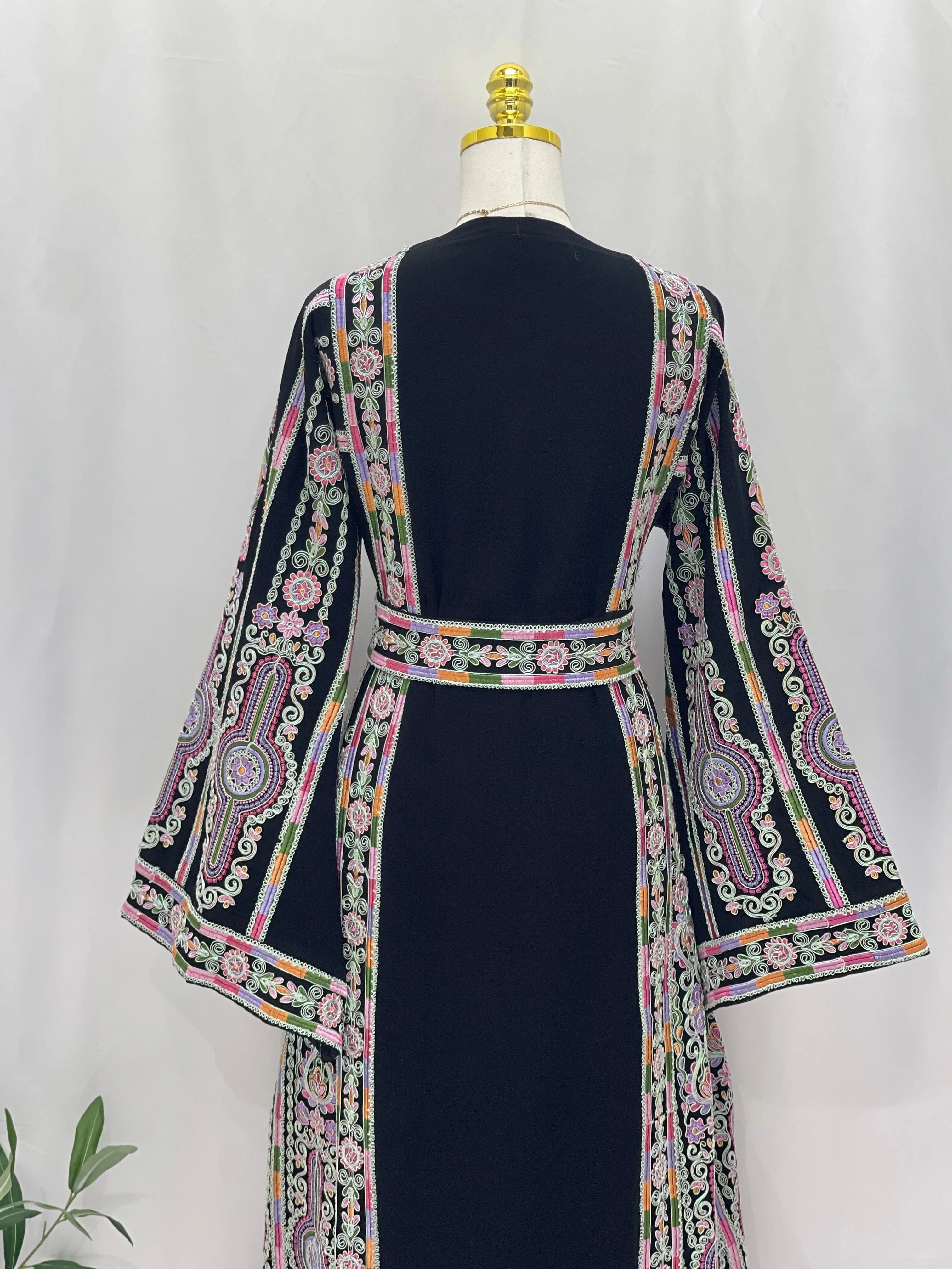 Silver Piping Embroidered Thobe back view on mannequin navy garment with colorful Palestinian embroidery belt and flared sleeves