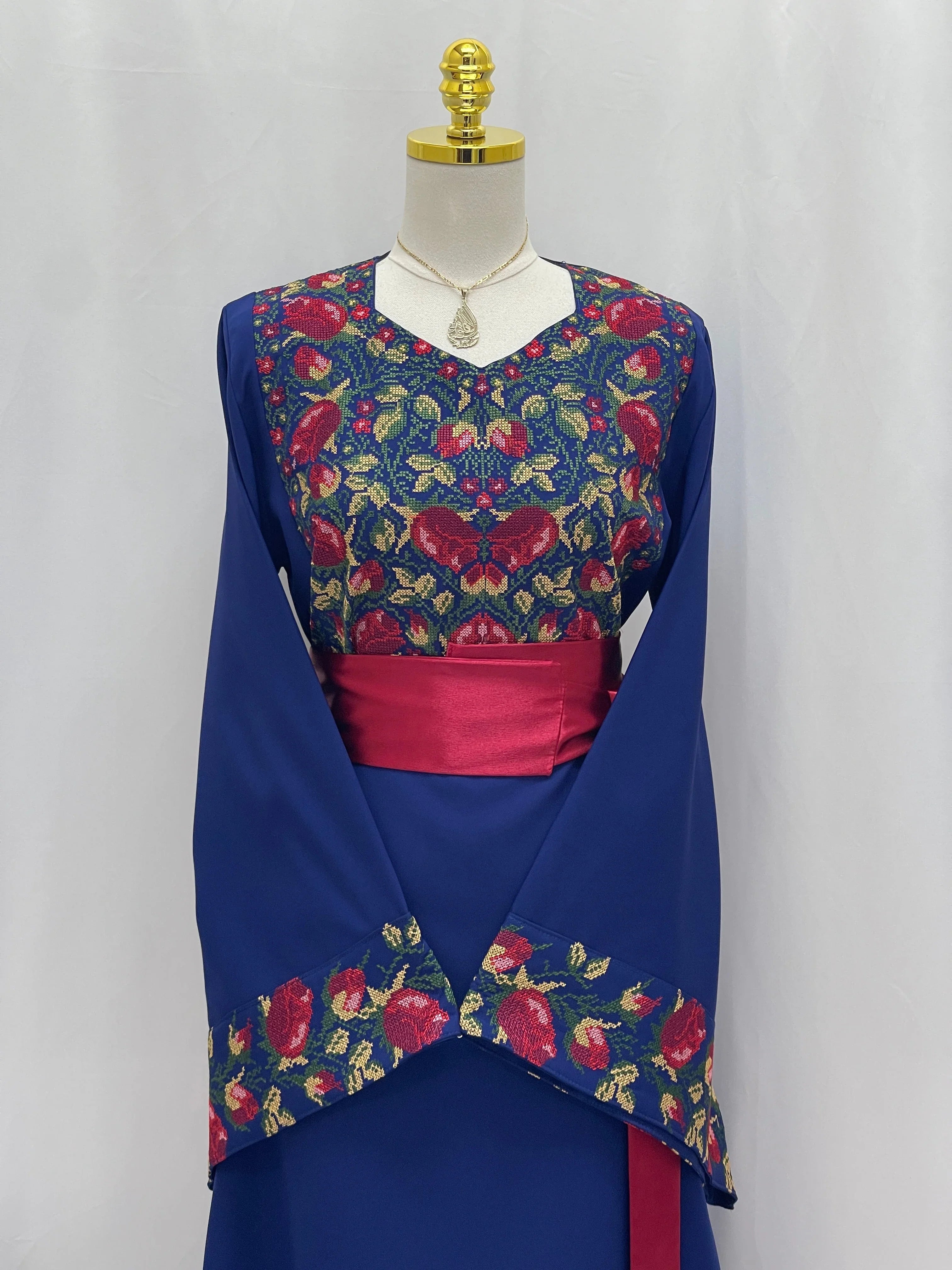 Palestinian Elegance Blossom Royal Blue Thobe with floral embroidery on bodice and sleeves and red waist sash
