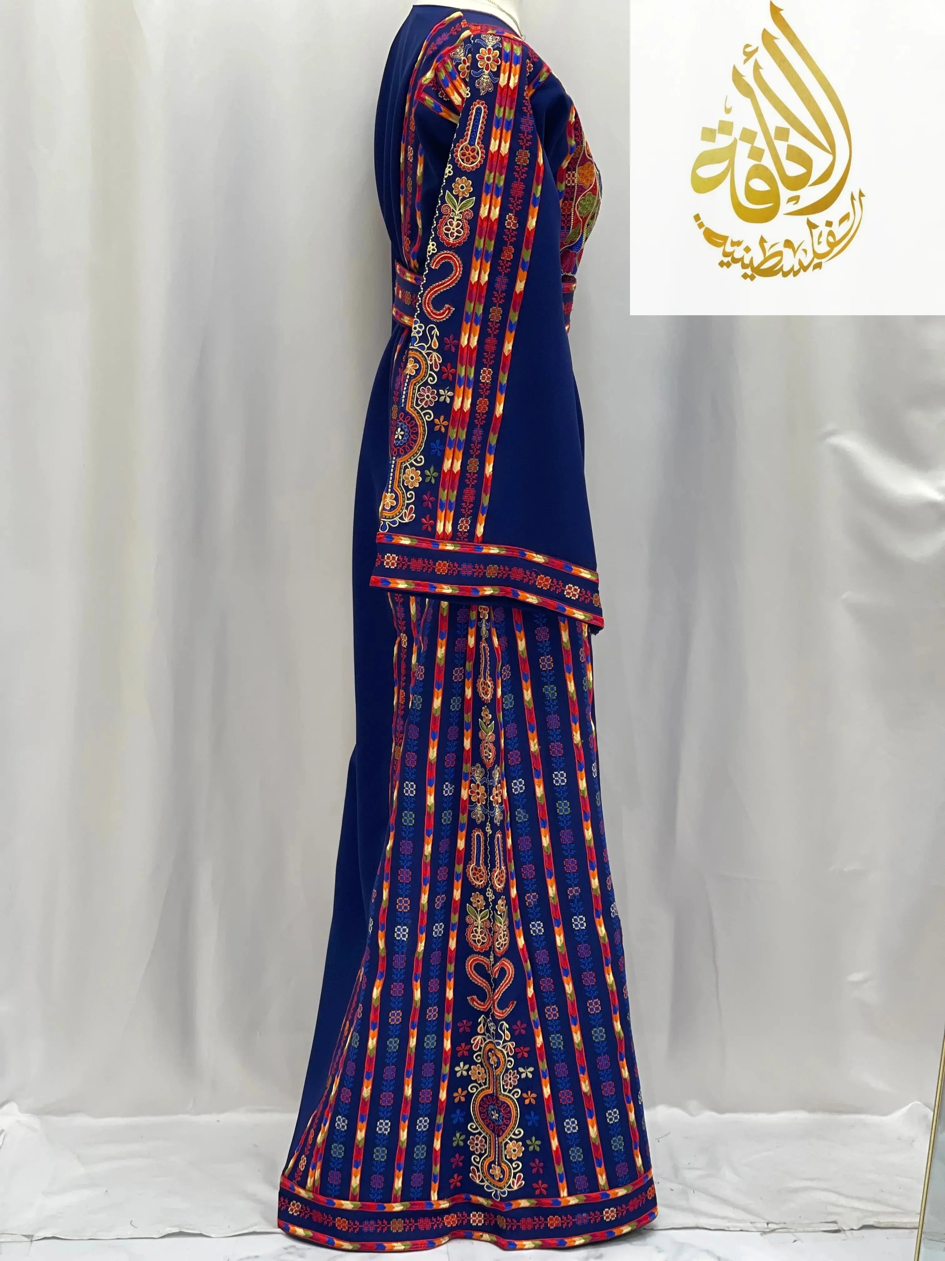 Side view of a blue embroidered Palestinian dress with intricate colorful traditional designs
