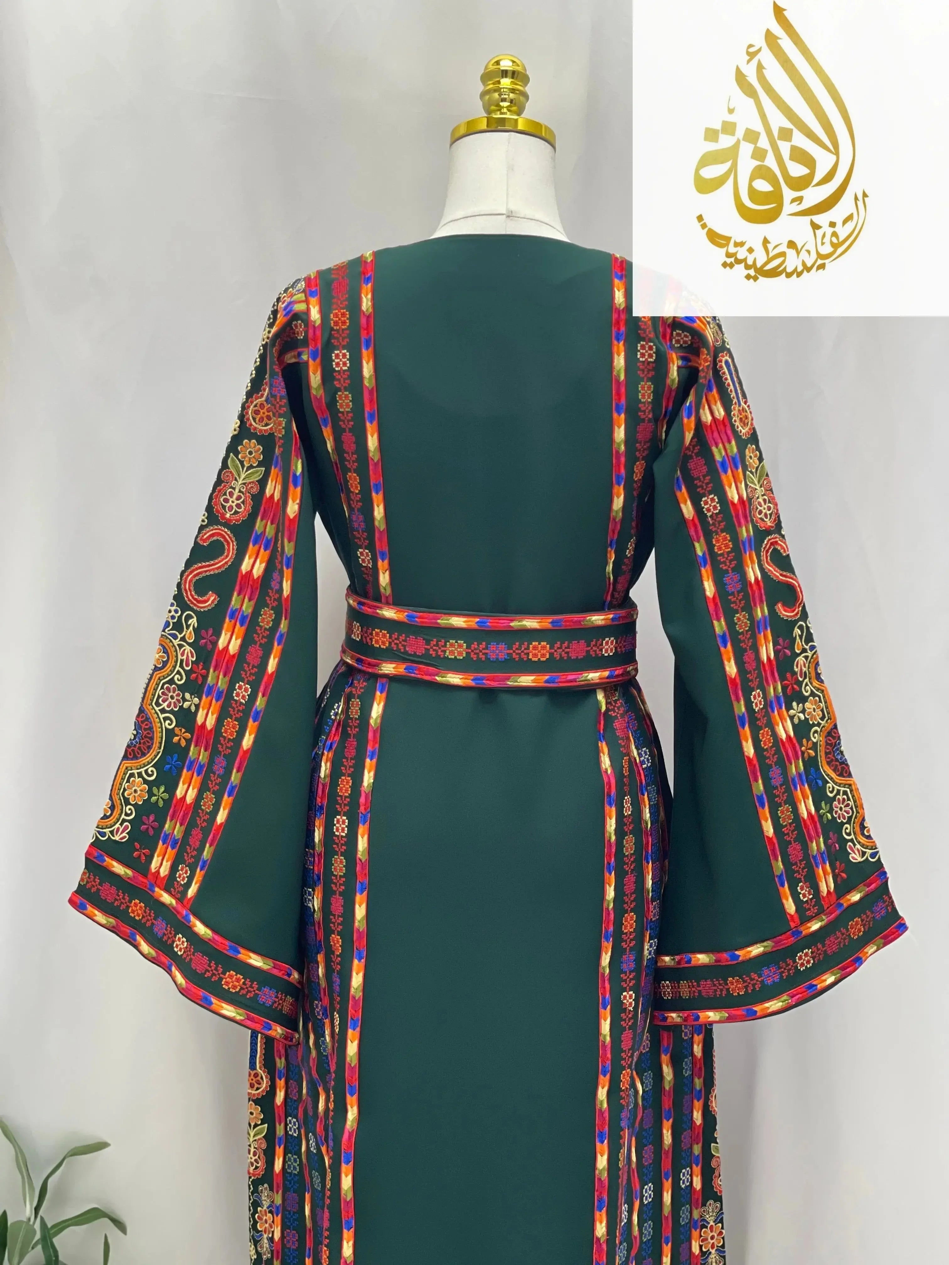 Back view of green embroidered Palestinian dress with colorful traditional patterns and belt from Palestinian Elegance