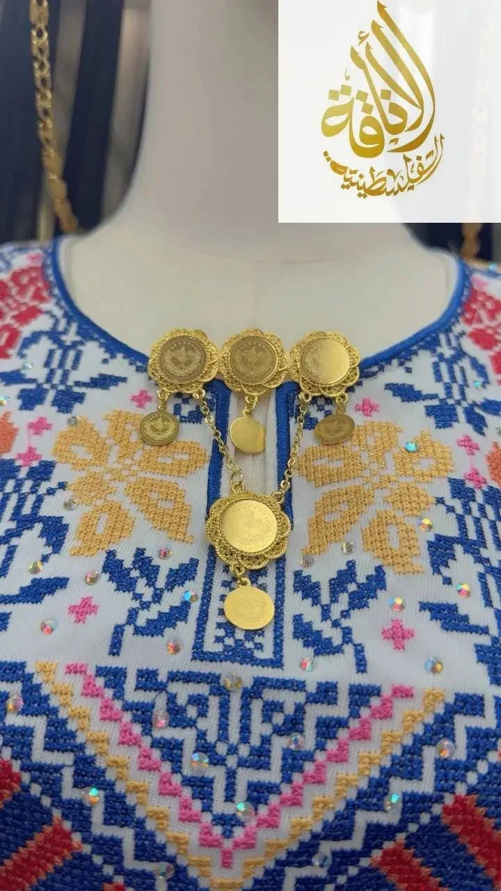 Traditional gold brooch in imitated gold by Palestinian Elegance displayed on embroidered fabric