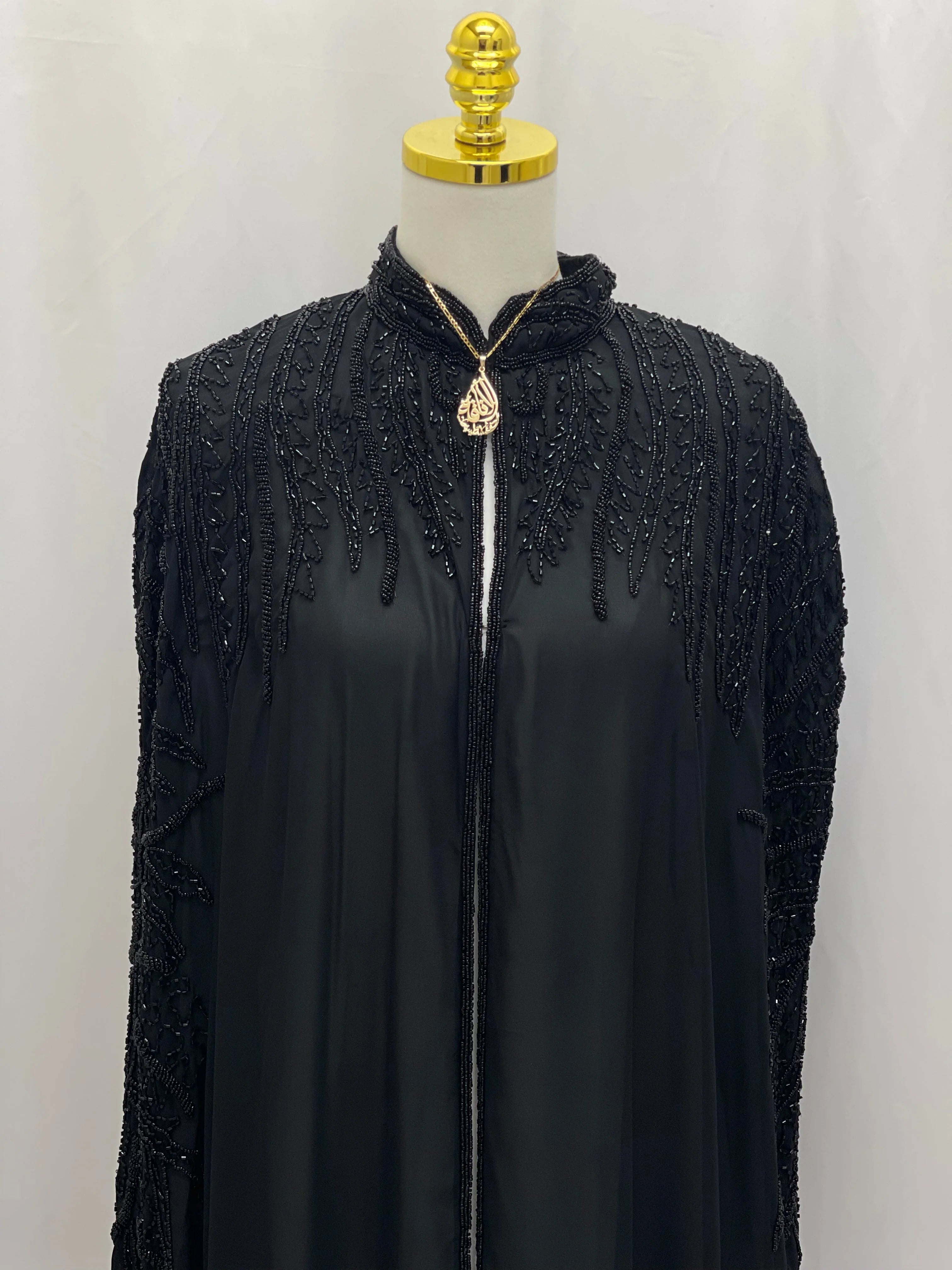 Black traditional embroidery cape by Palestinian Elegance with intricate beadwork on shoulders and neckline