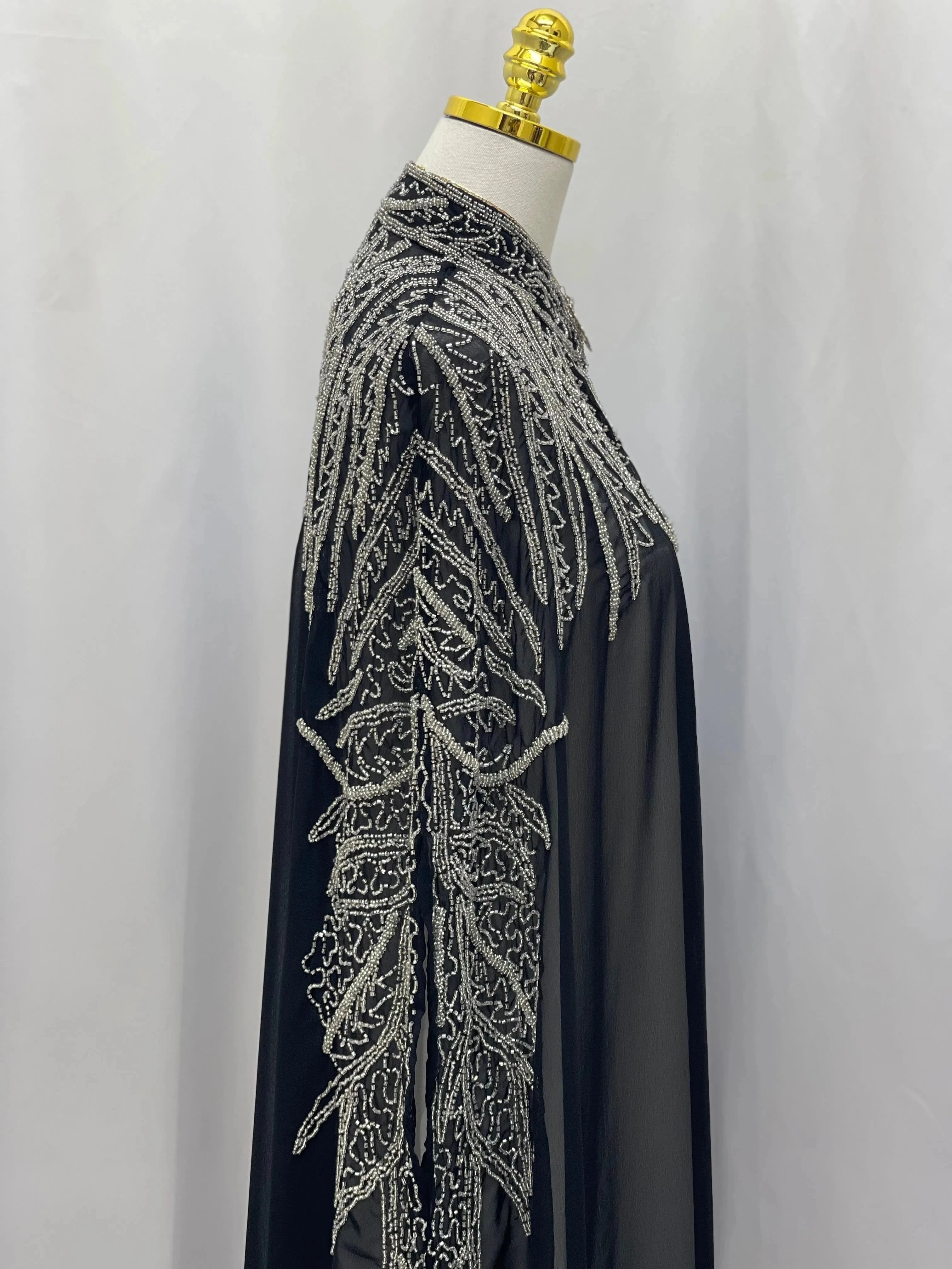 Black traditional embroidery cape with intricate silver thread detailing from Palestinian Elegance
