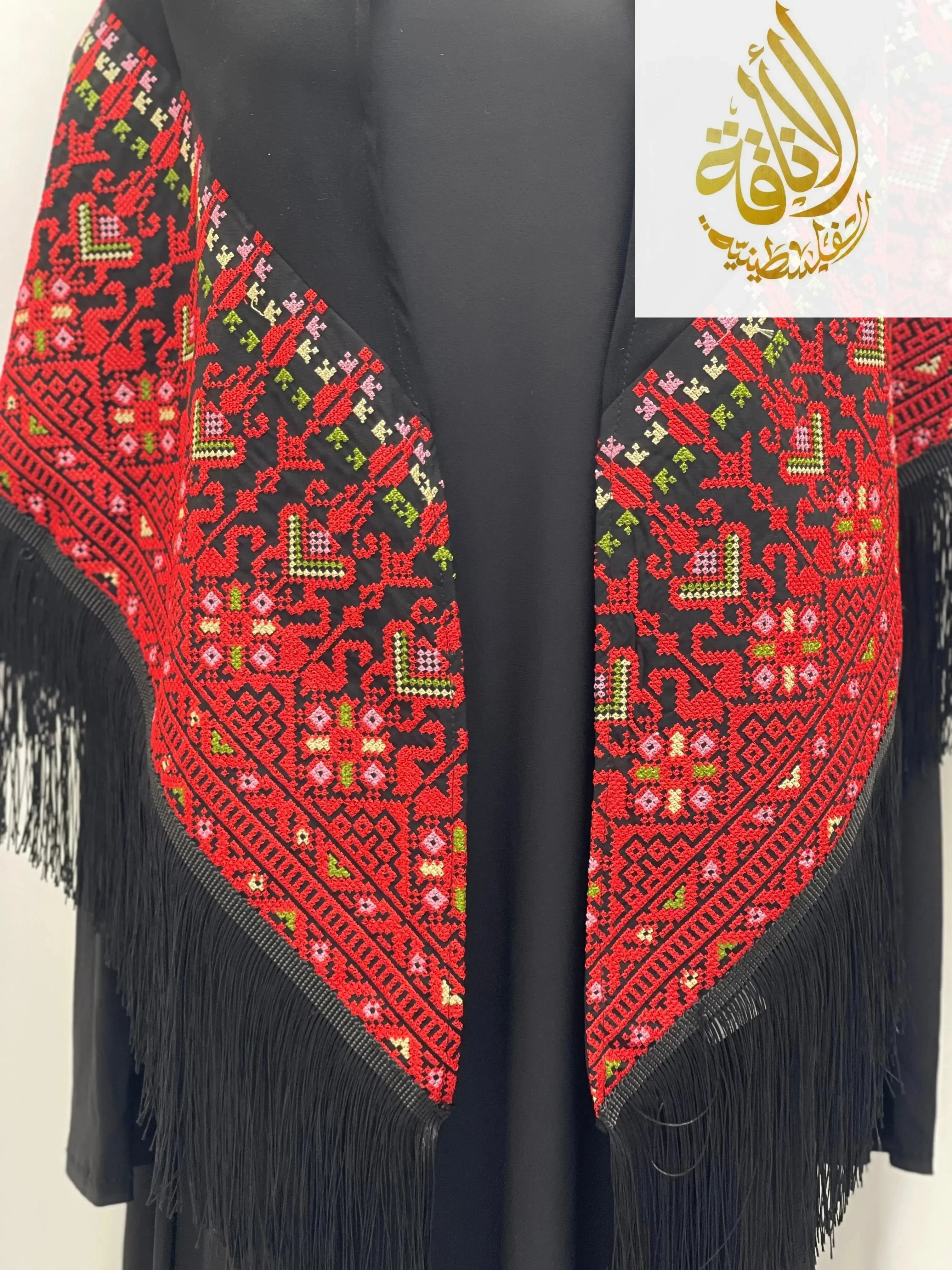 Palestinian embroidered shawl with red, green, and white traditional patterns and black fringe edges