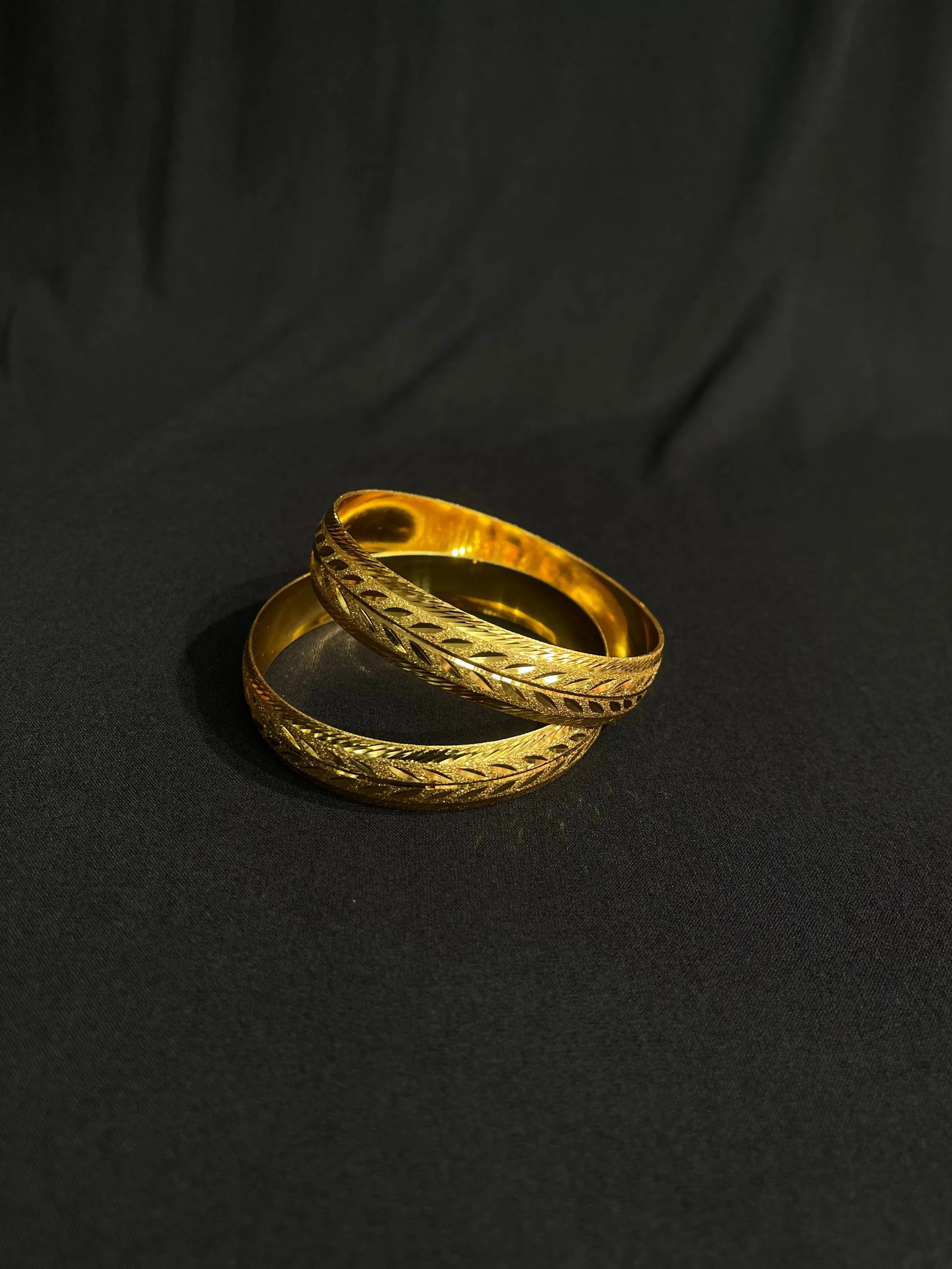 Imitated gold Leaf Bangles with traditional design showcasing intricate leaf patterns on a black background