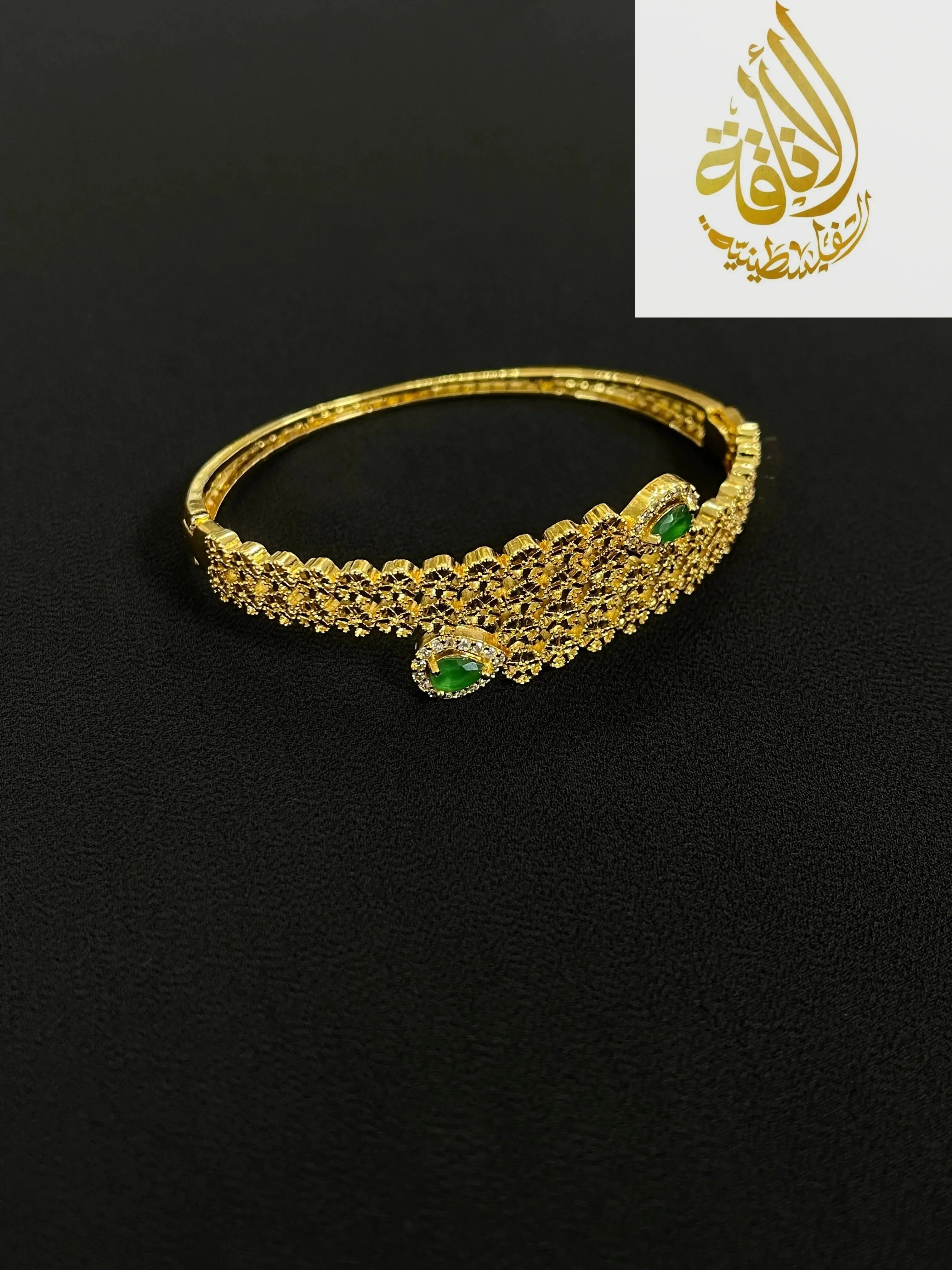 Elegant Palestinian gold jewelry set bracelet with green gemstone accents on black background