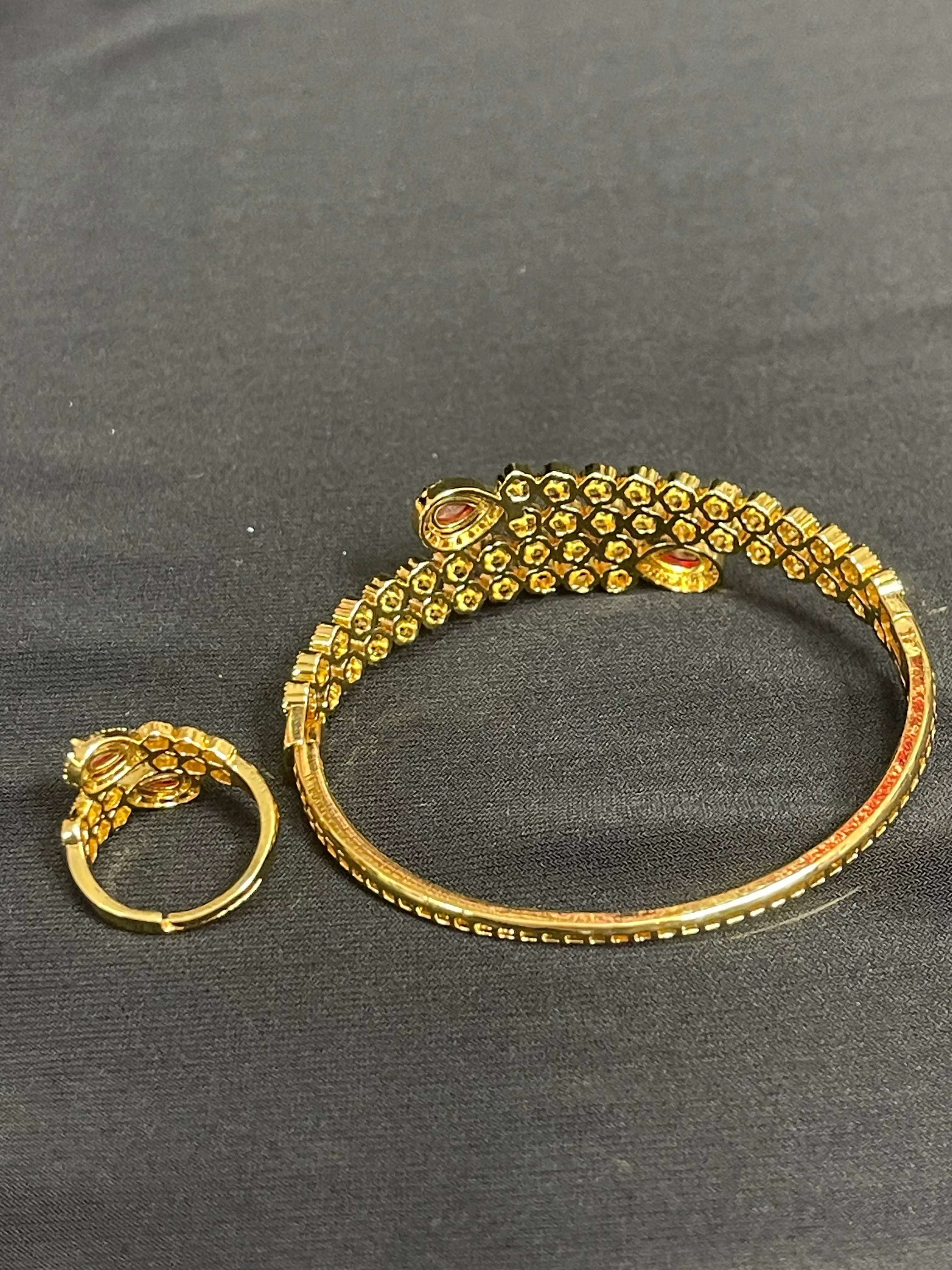 Palestinian gold jewelry set featuring a detailed gold bracelet and matching ring on a black fabric background