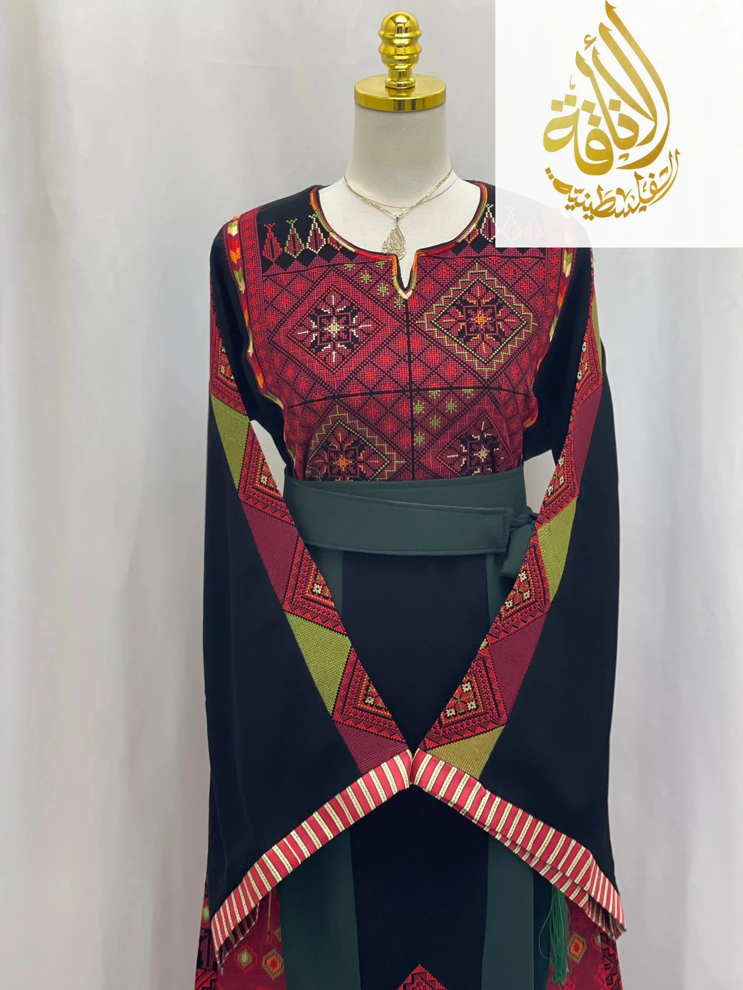 Embroidered Palestinian thoub with traditional red and green geometric patterns by Palestinian Elegance