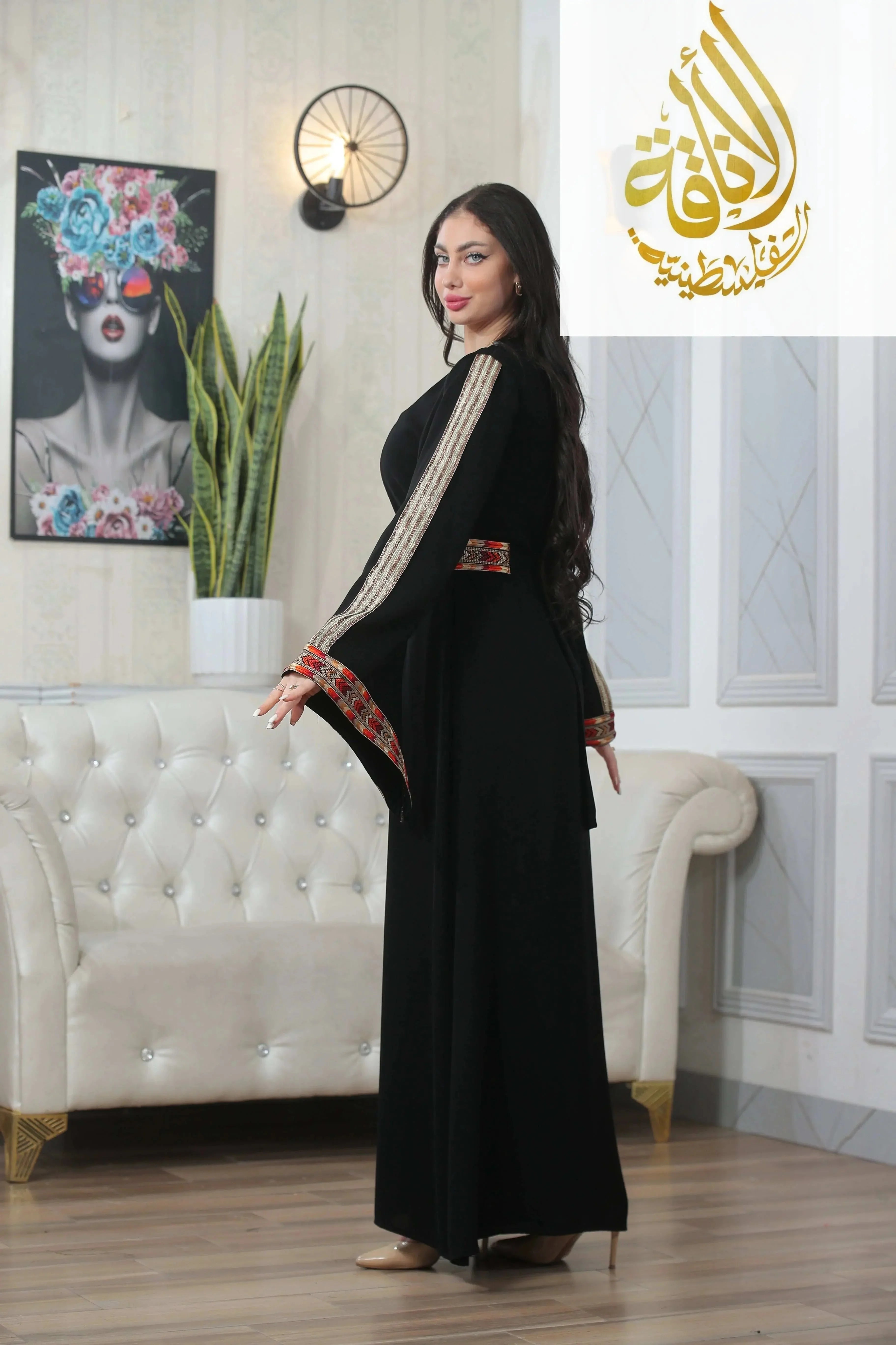 Woman wearing a black Zena Embroidered Thoub with gold and red detailed embroidery by Palestinian Elegance