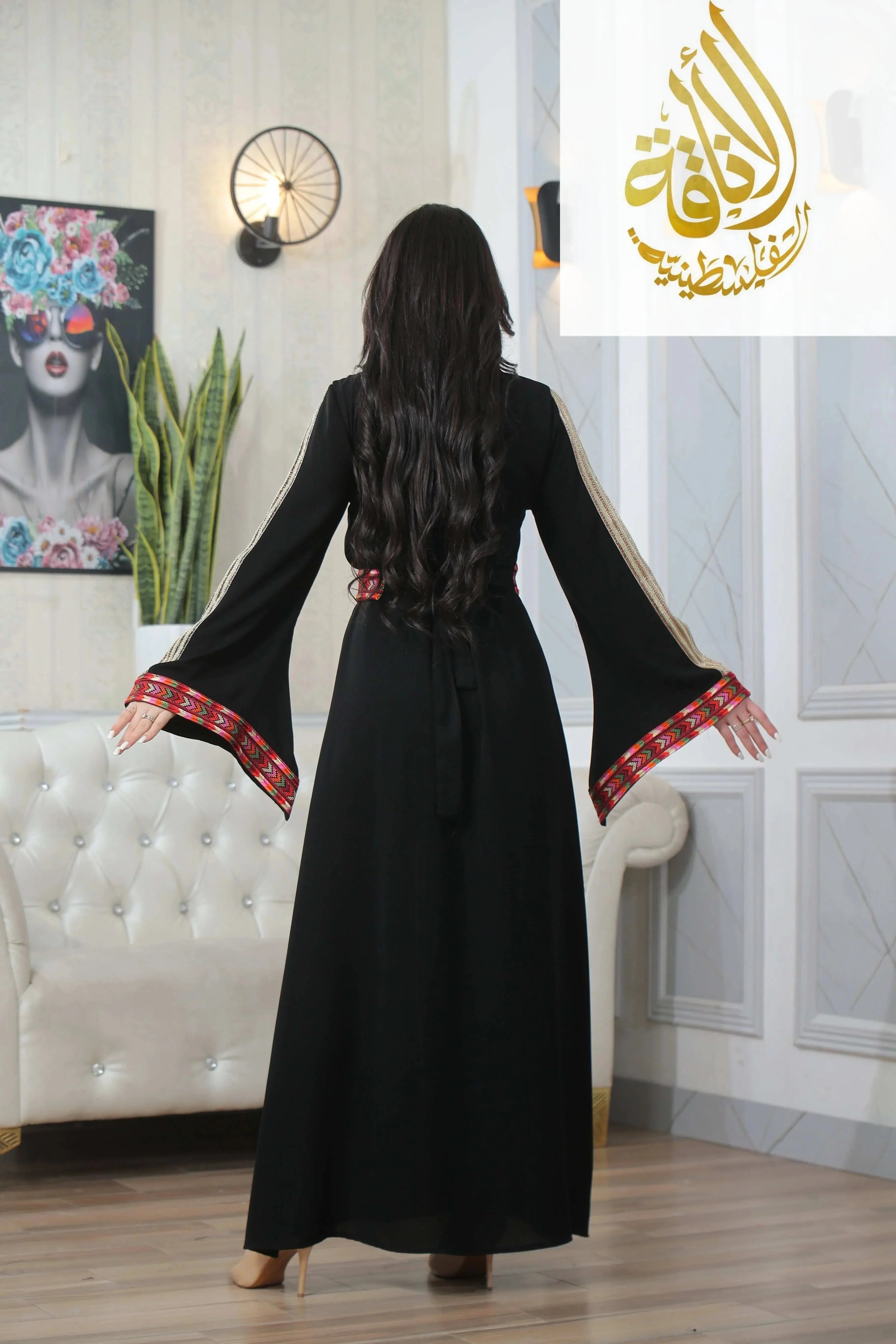 Back view of Zena Embroidered Thoub by Palestinian Elegance featuring black fabric with red embroidered cuffs