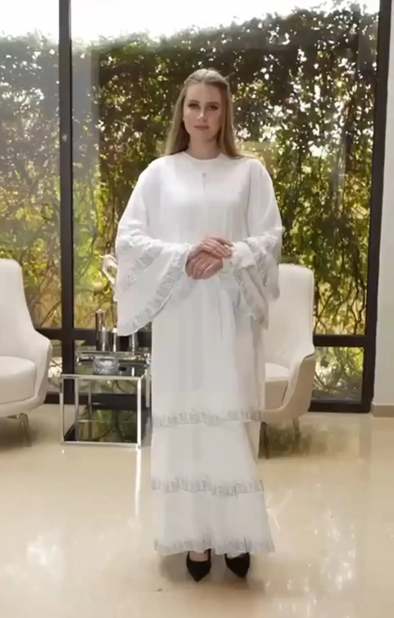 Palestinian Elegance white abaya with strass embellishments featuring flowing sleeves and decorative trim