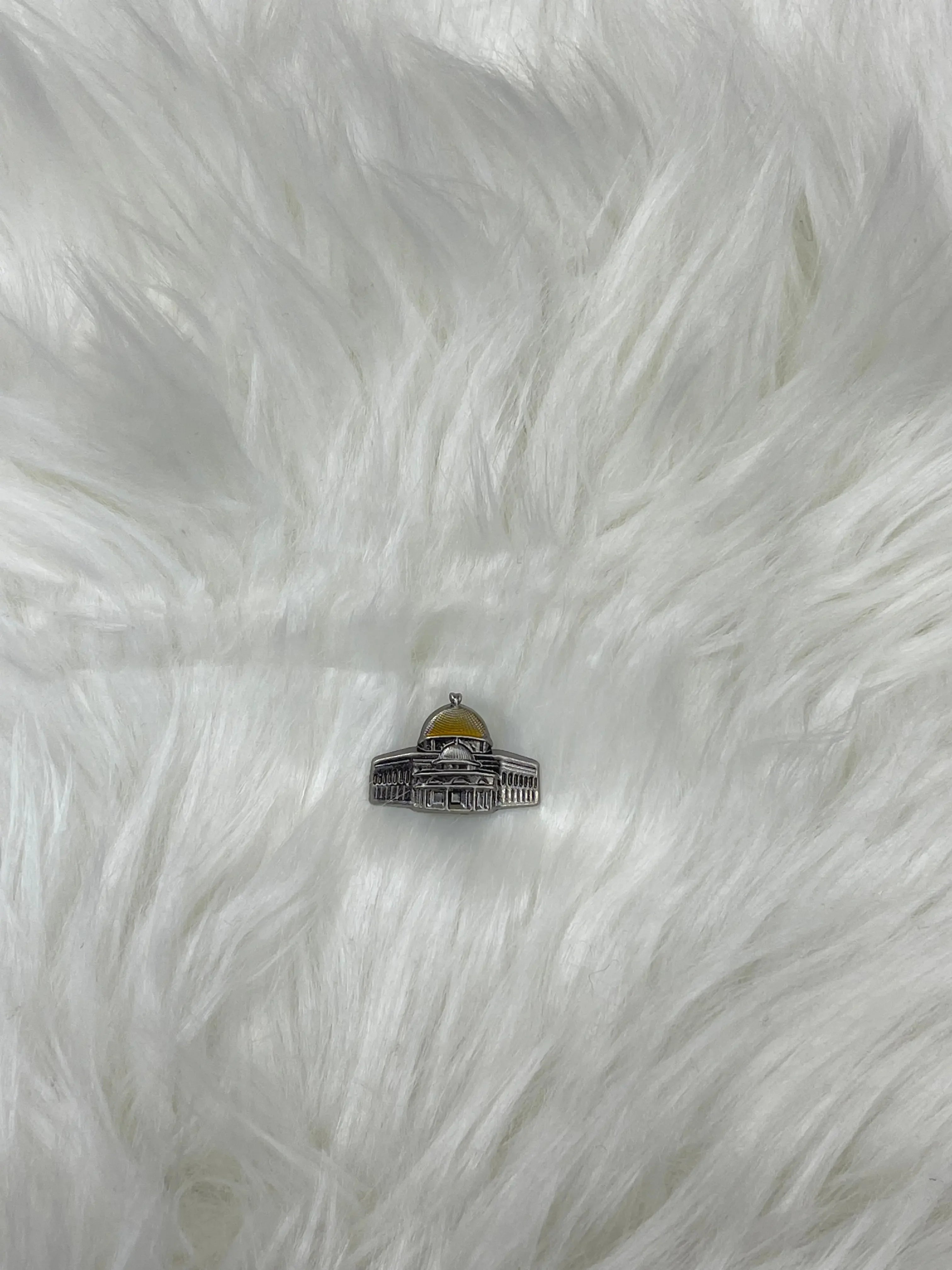Aqsa pin Aqsa Pin Metal featuring a detailed silver and gold Dome of the Rock design on white fur background