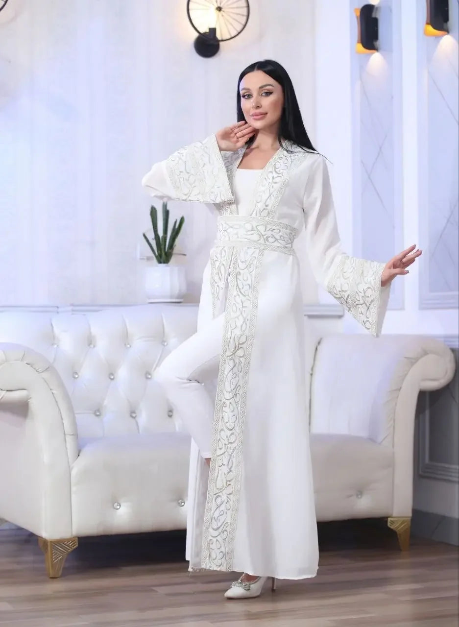 Elegant white Arabic letter embroidered cardigan with wide sleeves and belt worn by woman indoors